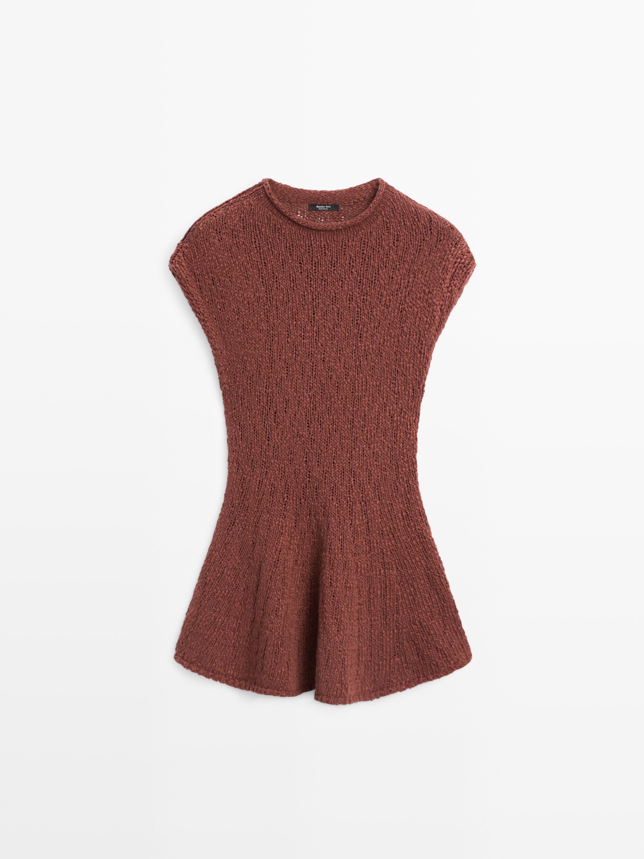 Vue de face d'un top en tricot tuile, sans manches, col rond, coupe évasée en bas.