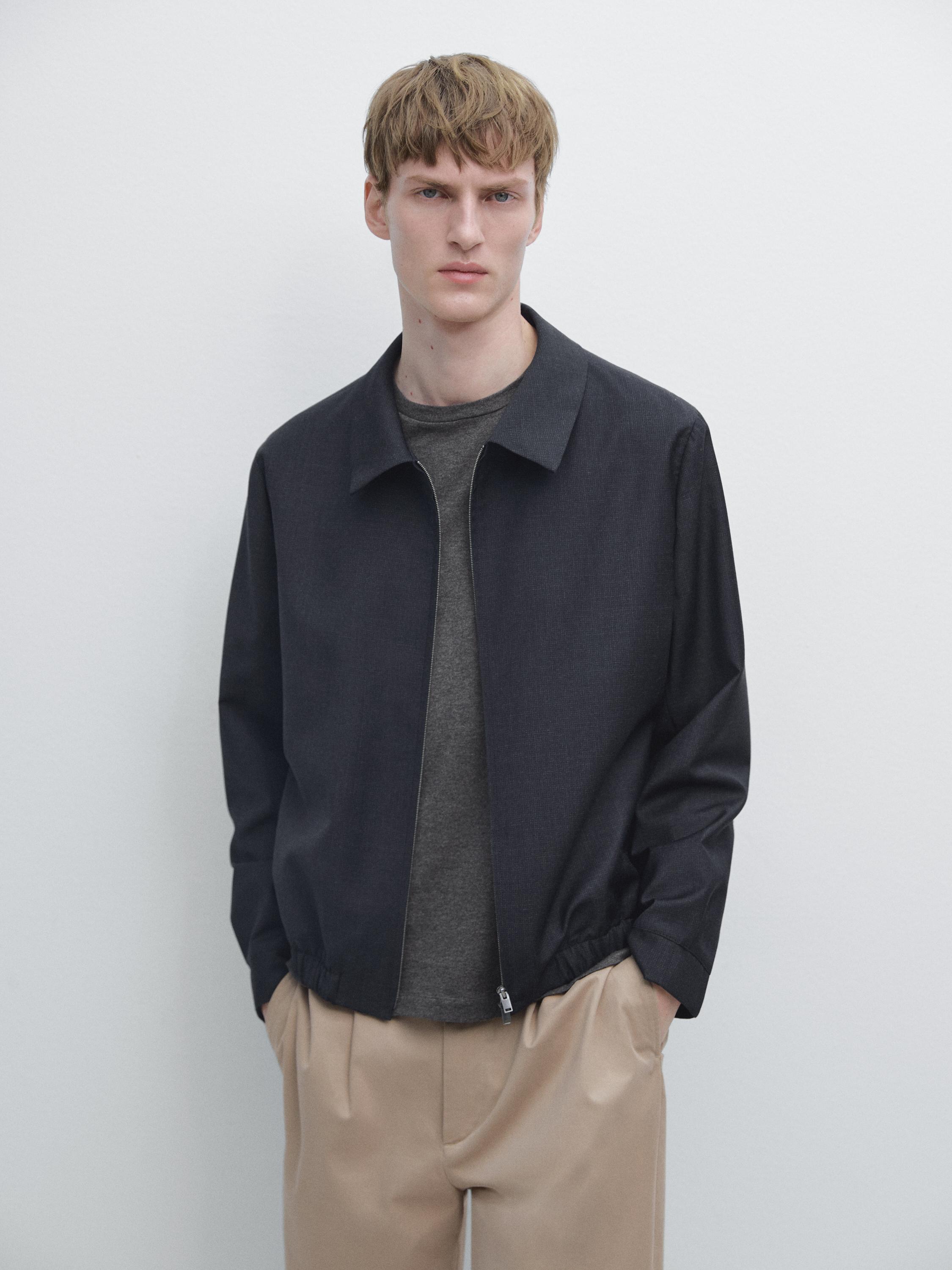 Ensemble de blouson bleu marine zippé et pantalon beige à pinces.