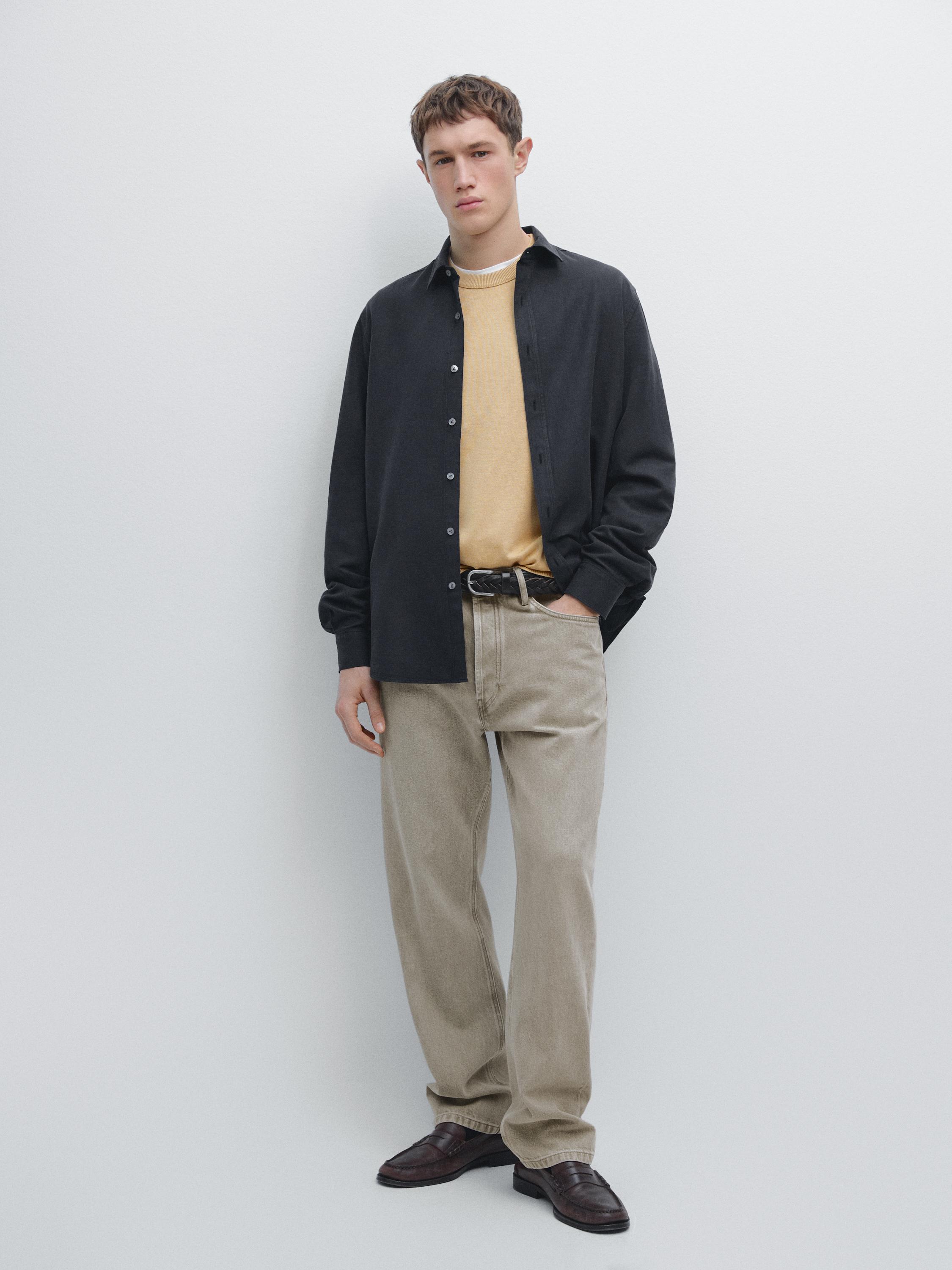 Комплект: темно-синяя рубашка с длинным рукавом, бежевая футболка, бежевые брюки и коричневые туфли.