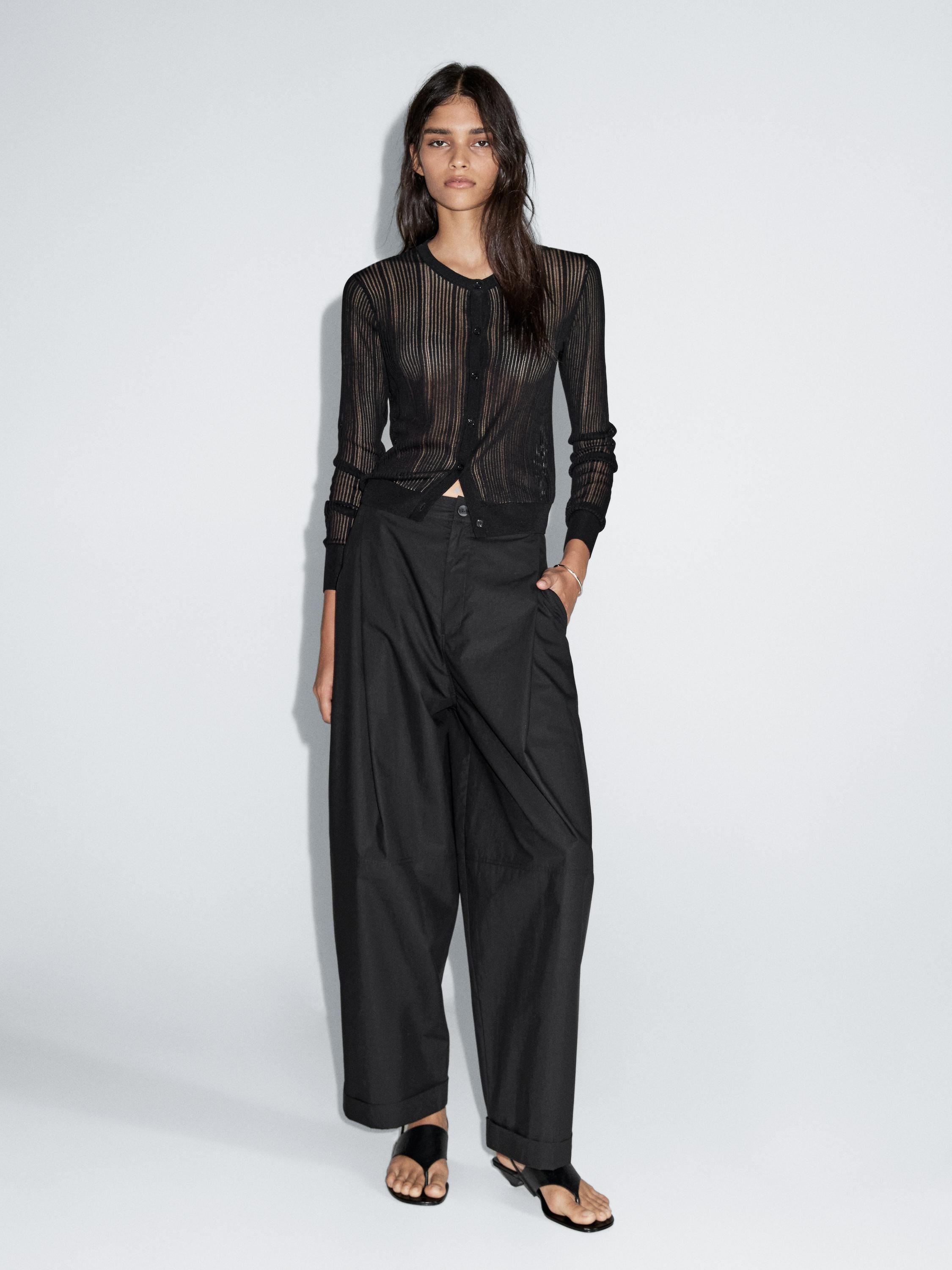 Black barrel fit pants set with hem and sheer black vertical striped cardigan.