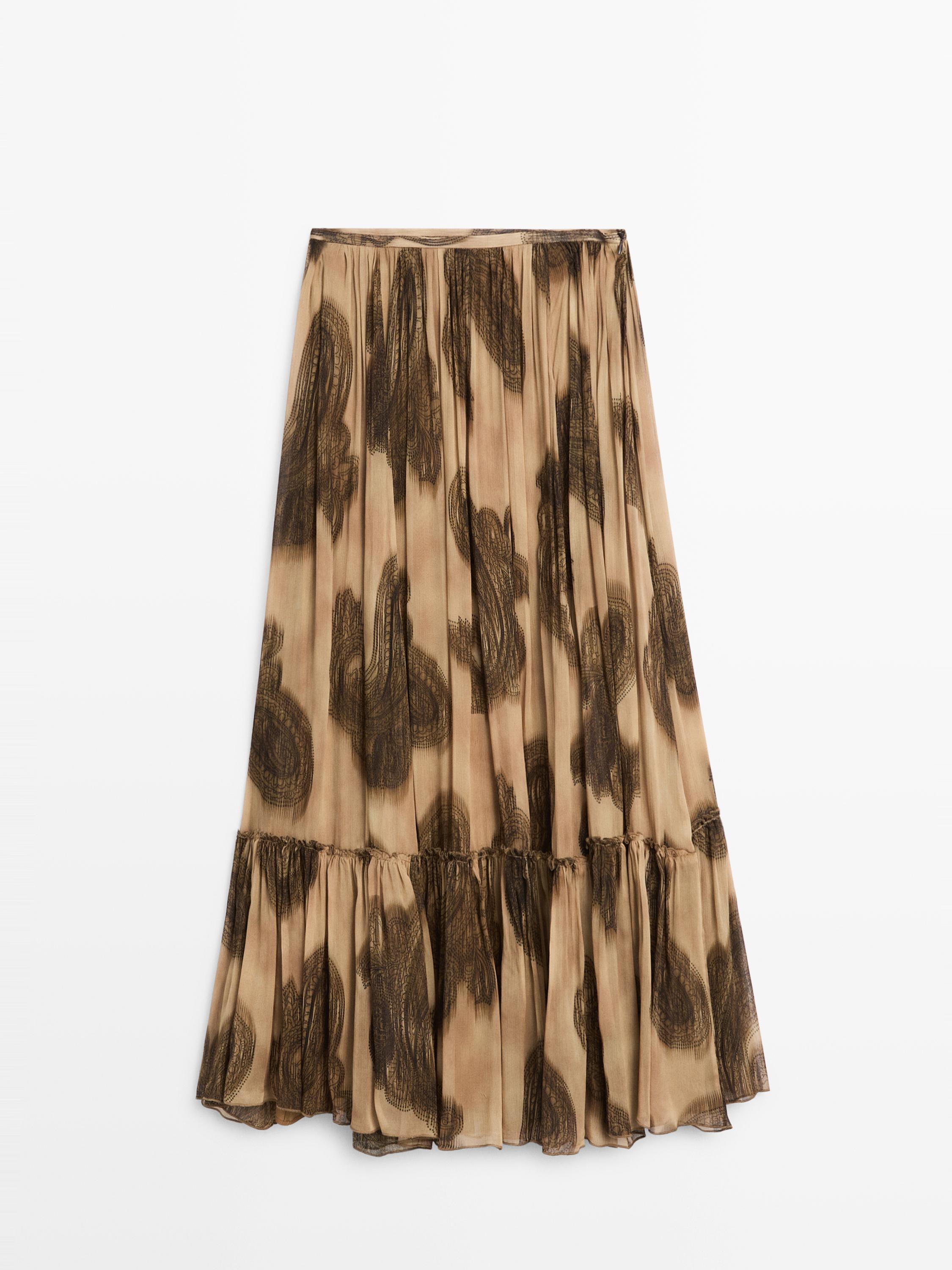 Front view of a long dusty pink skirt with a paisley print in dark tones and ruffles at the hem.