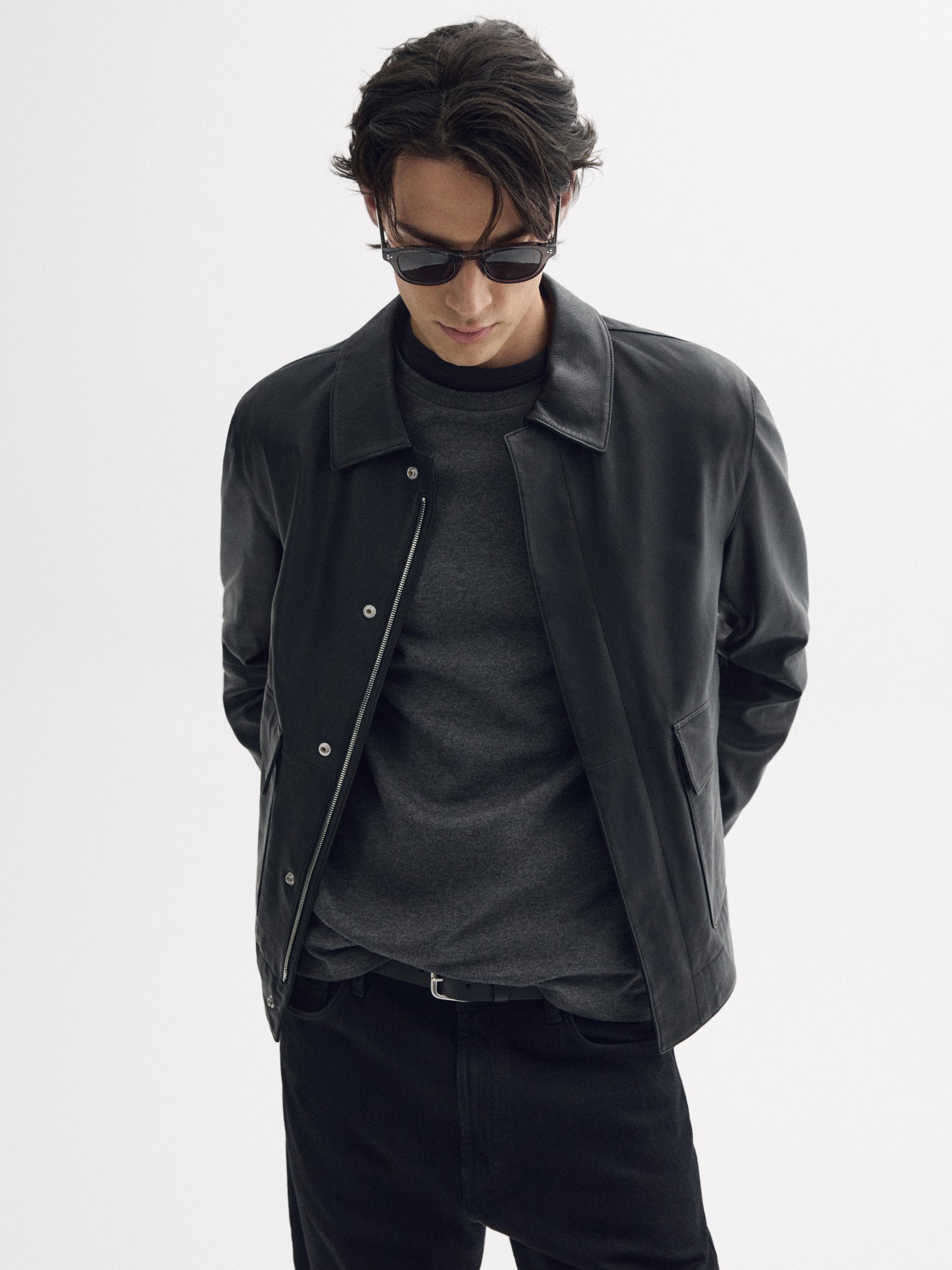 버튼이 달린 검은색 재킷, 회색 티셔츠, 검은색 청바지 세트.