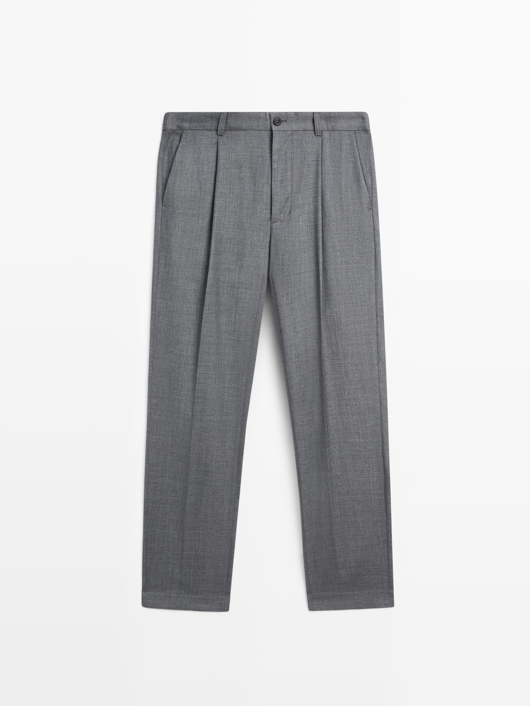 Vue de face d'un pantalon gris relaxed fit avec pinces et poches latérales.