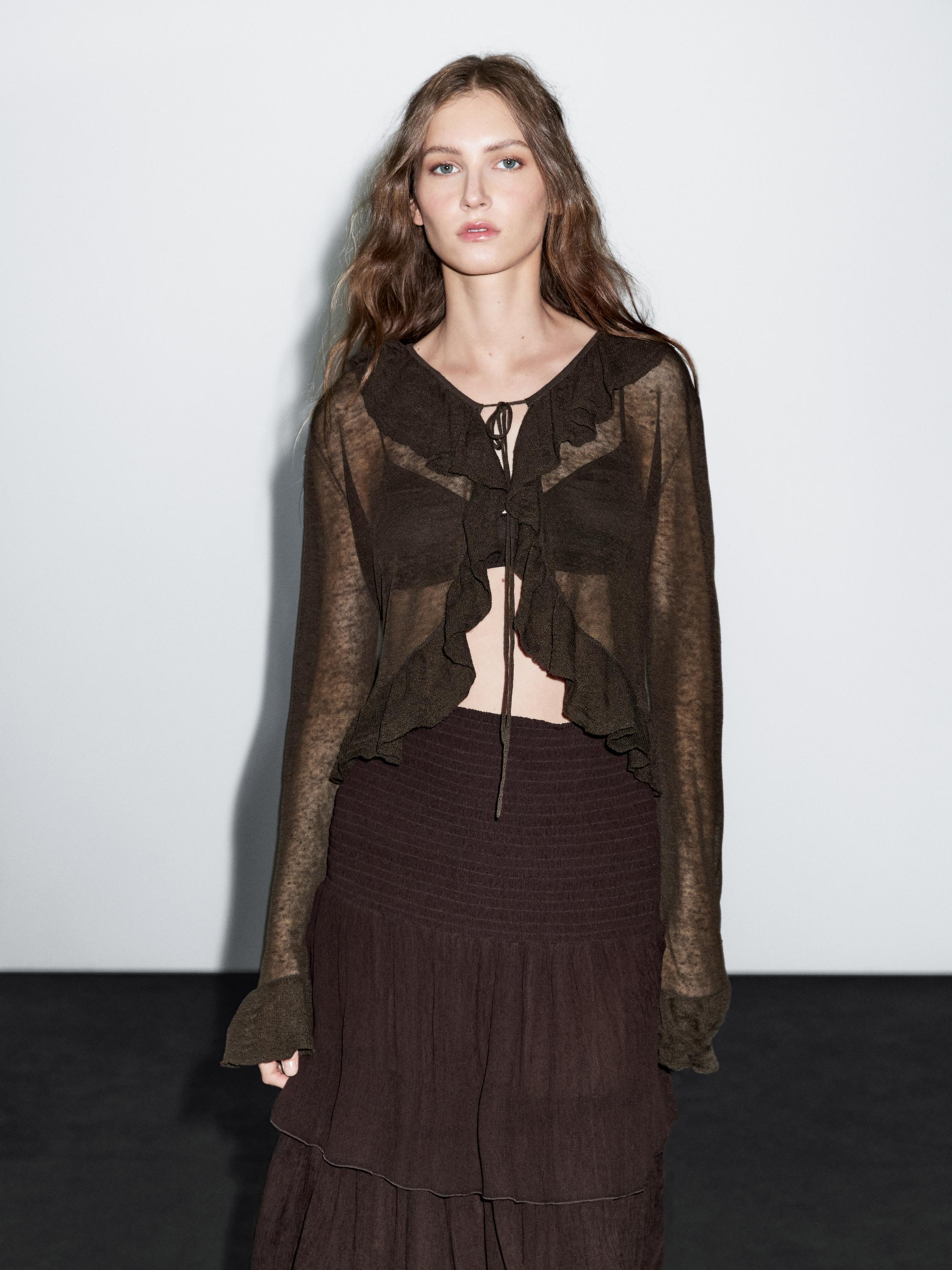 Semi-sheer brown cardigan set with ruffles, chest tie, and long sleeves, paired with a layered brown skirt.