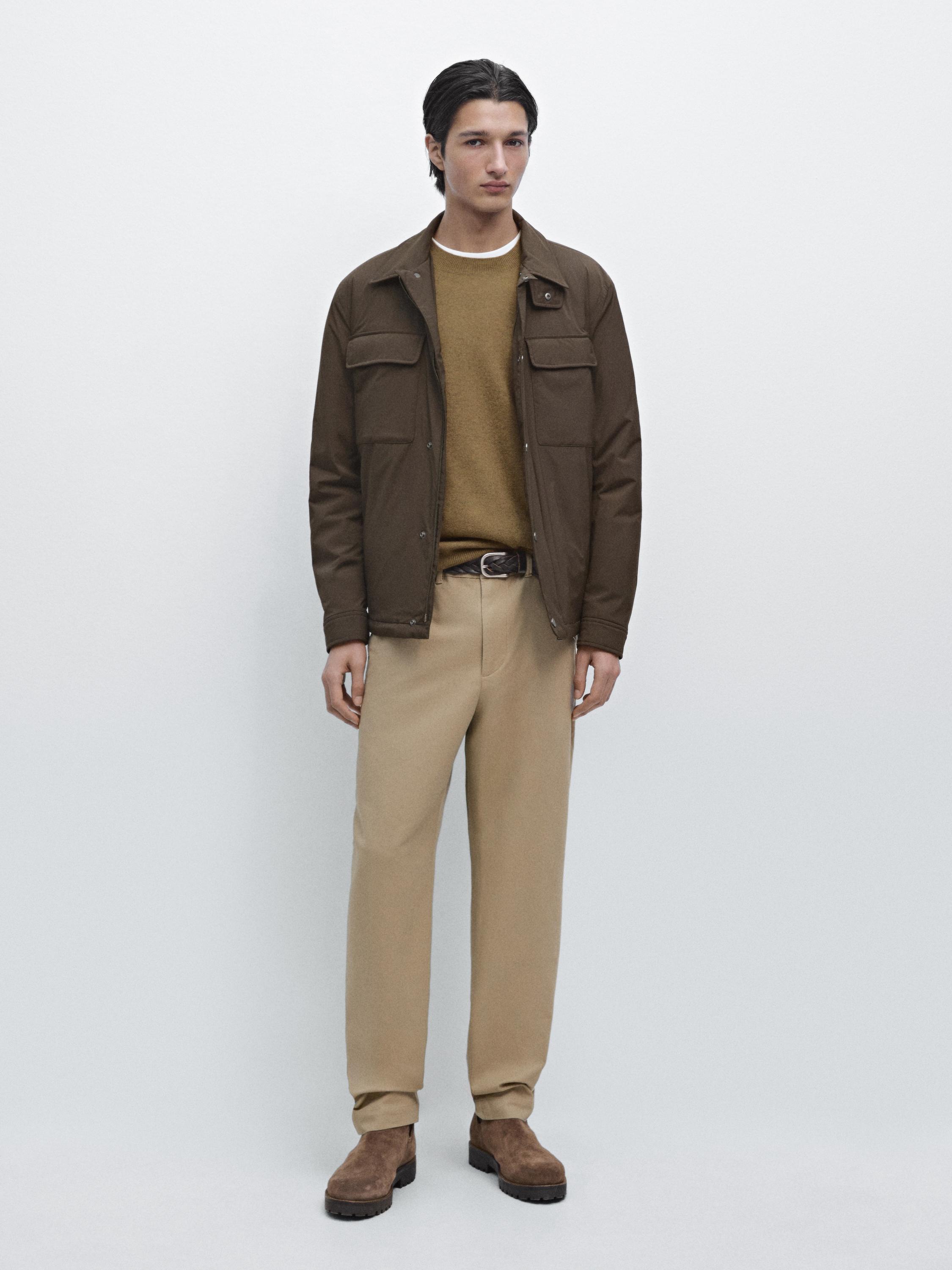 Brown jacket set with front pockets, tan sweater, tan pants, and brown boots.