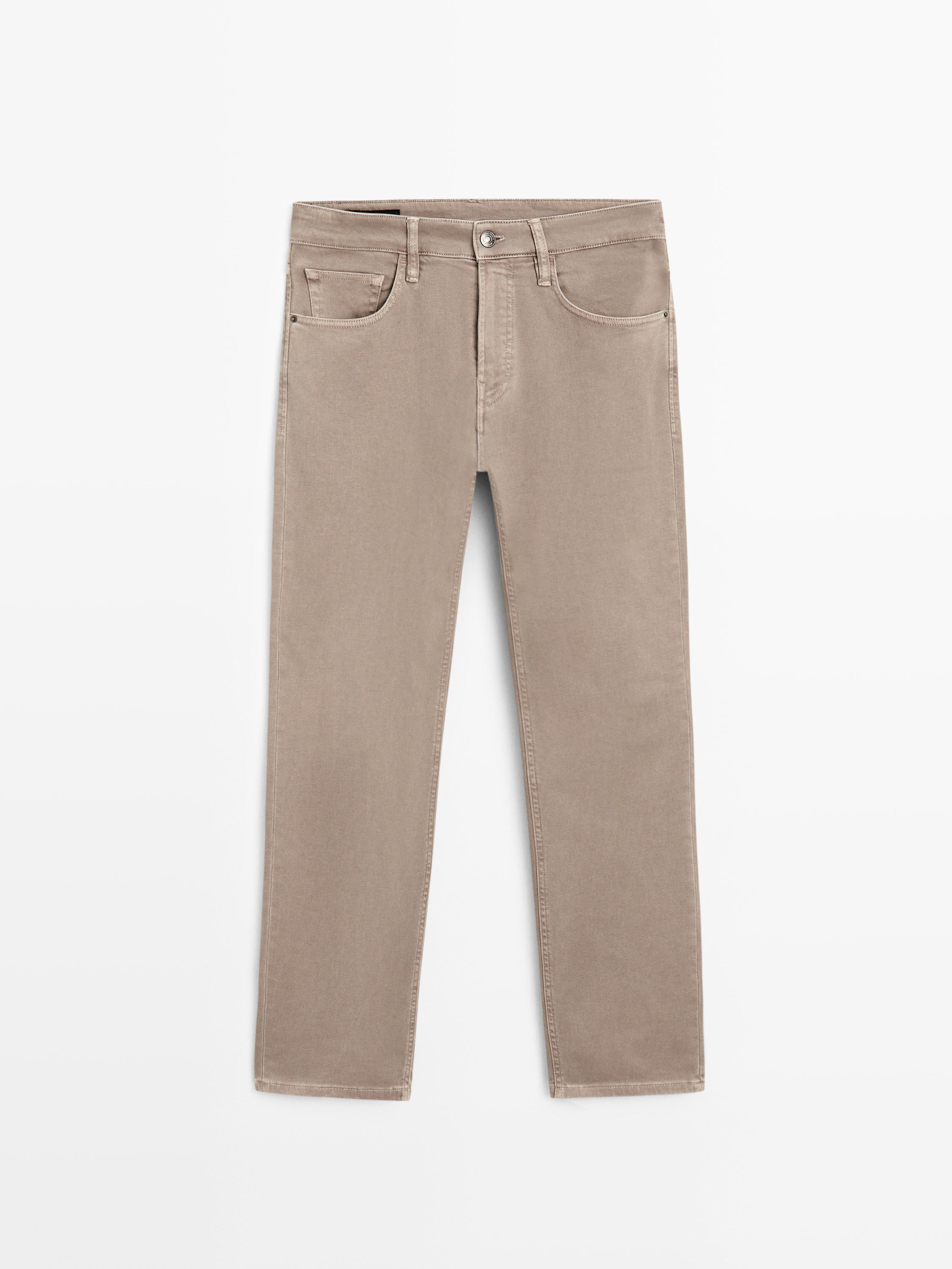 Front view of mink tapered fit jeans with front and back pockets, button and zipper closure.