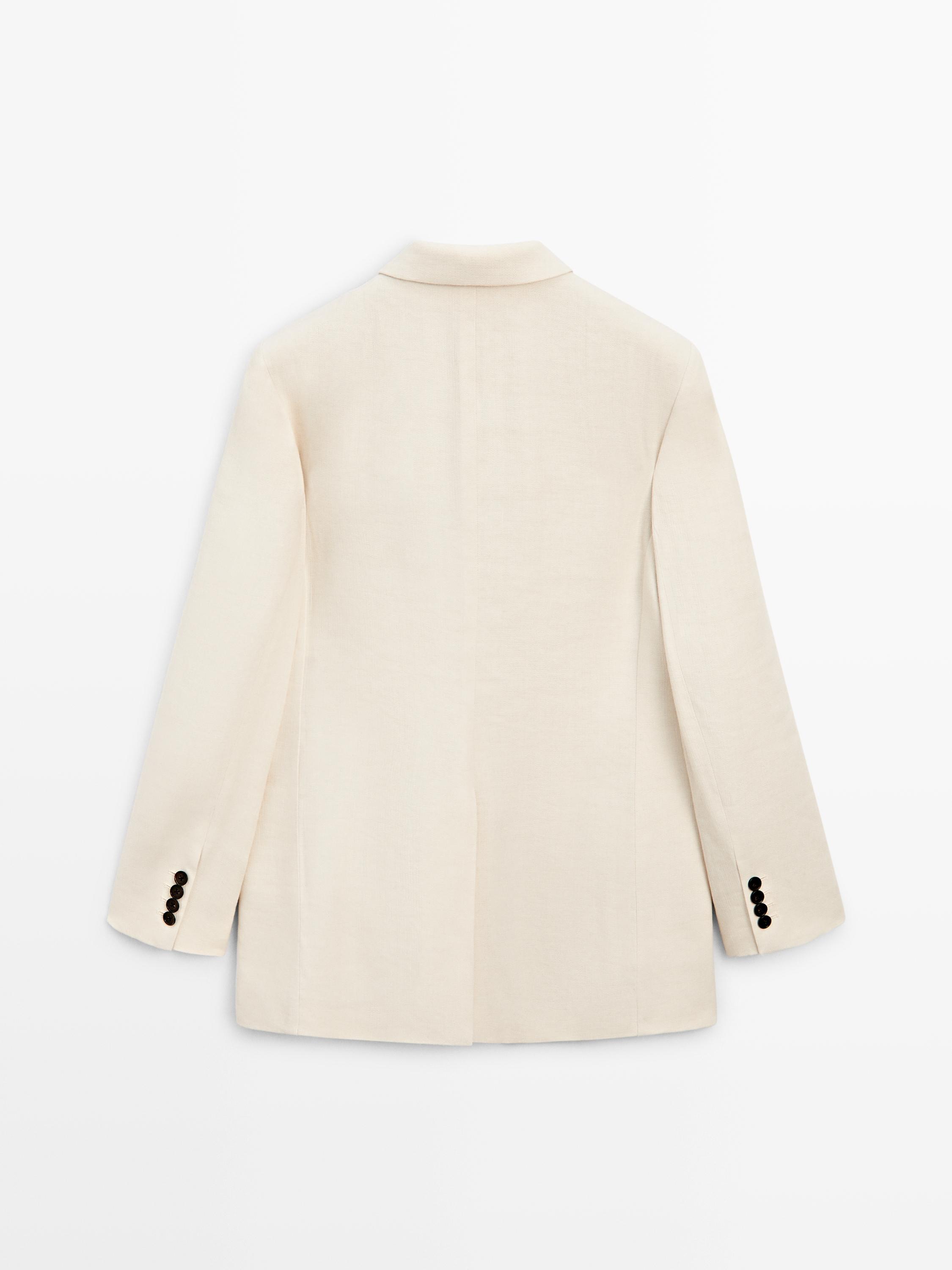 Rückenansicht eines rohweißen Blazers mit klassischem Revers und schwarzen Knöpfen an den Manschetten.