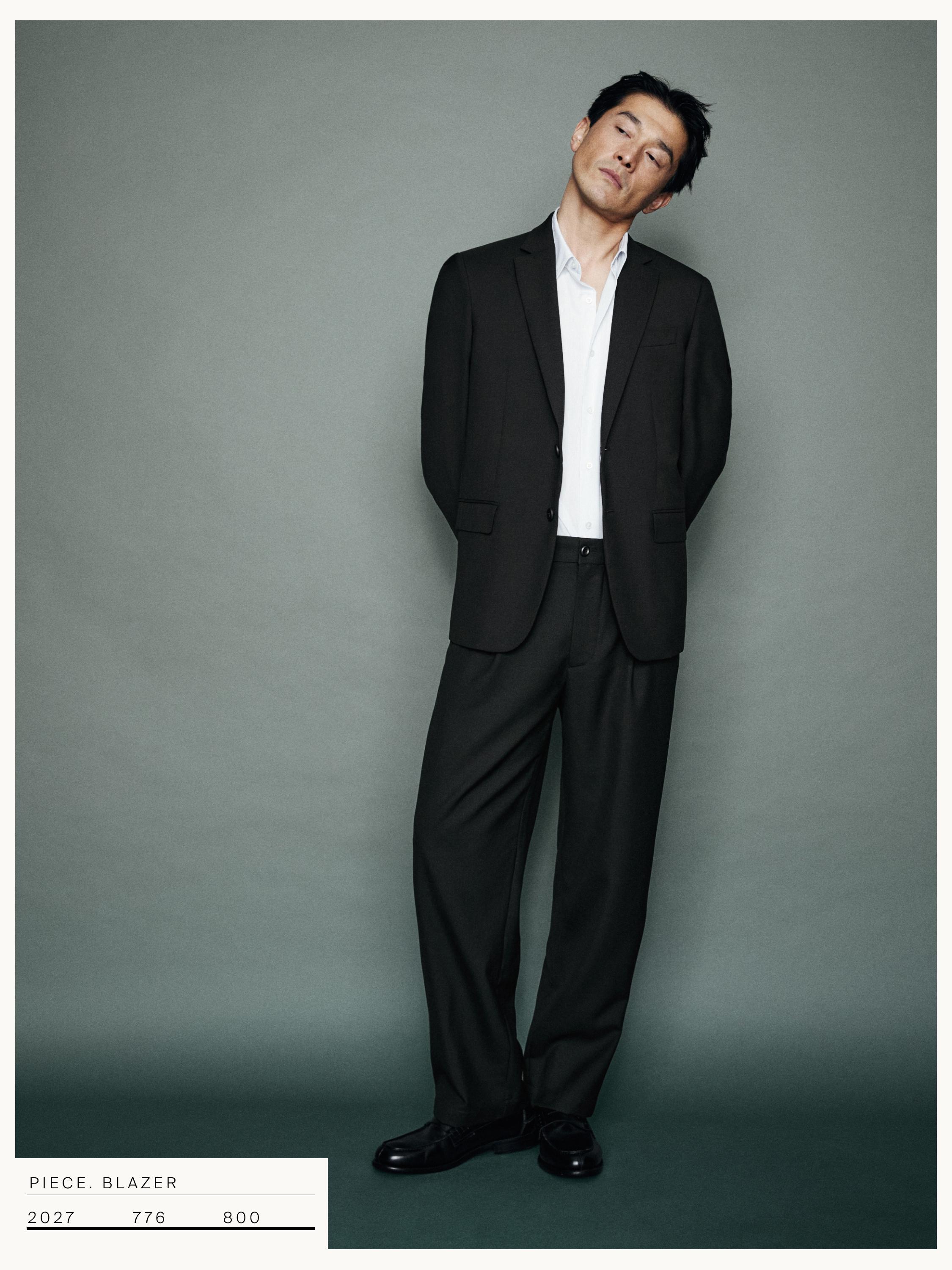 Traje beltz multzoa, bi botoiko jakarekin, alkandora zuriarekin eta praka zuzenekin.