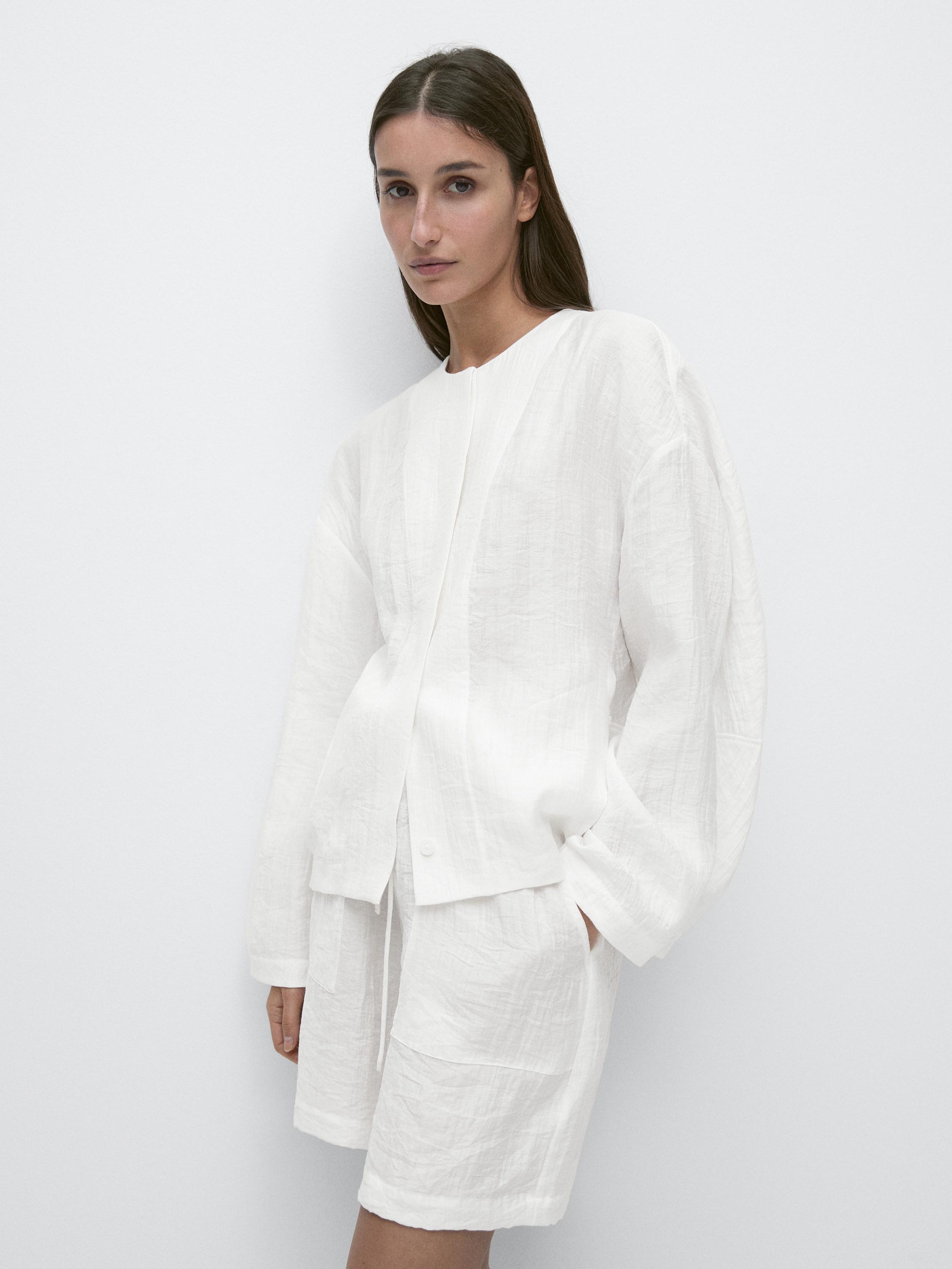 Conjunto de camisa blanca de manga larga sin cuello y bermudas a juego con bolsillos laterales.