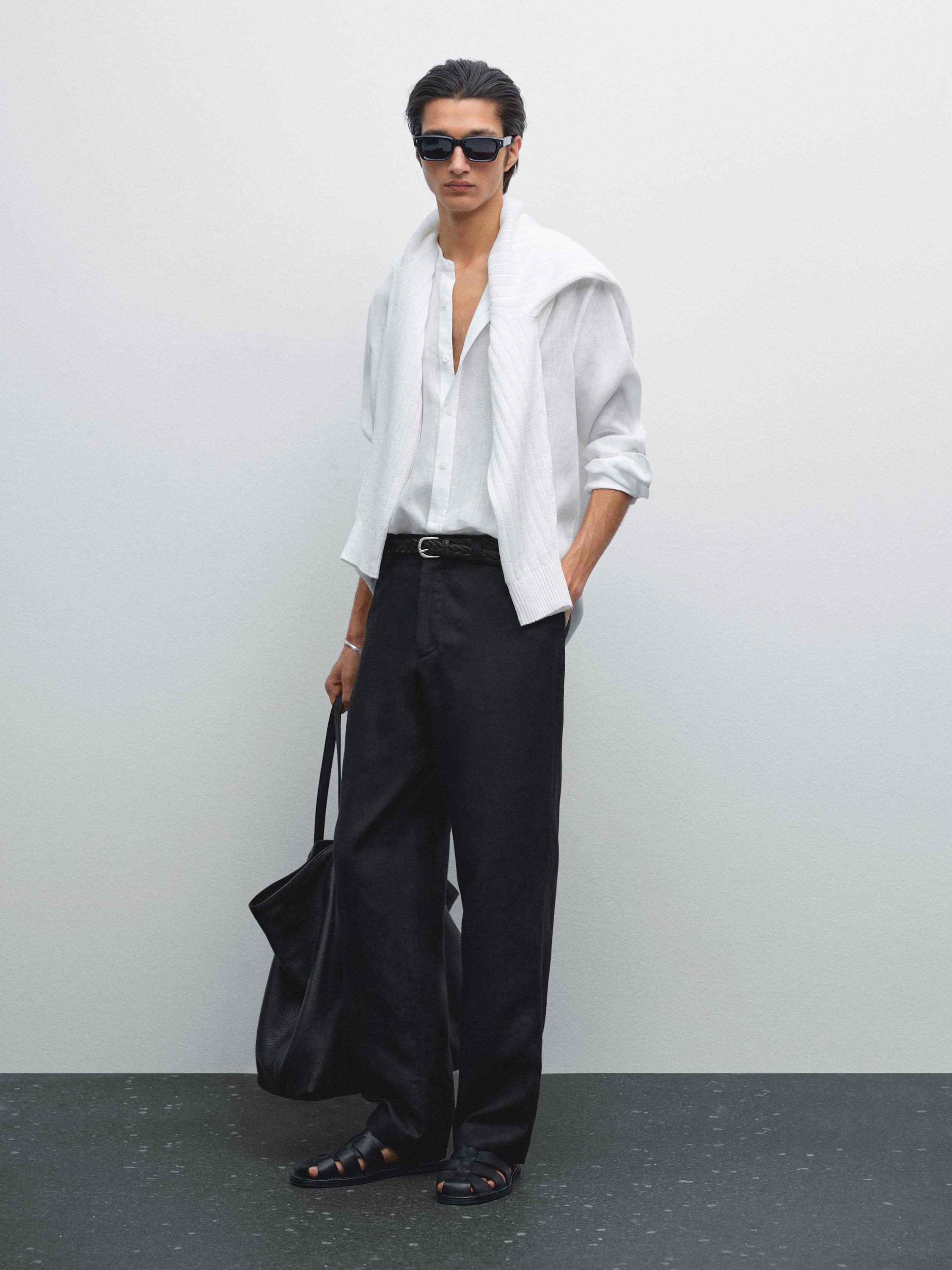 Outfit of a white shirt, wide black pants, and black sandals.
