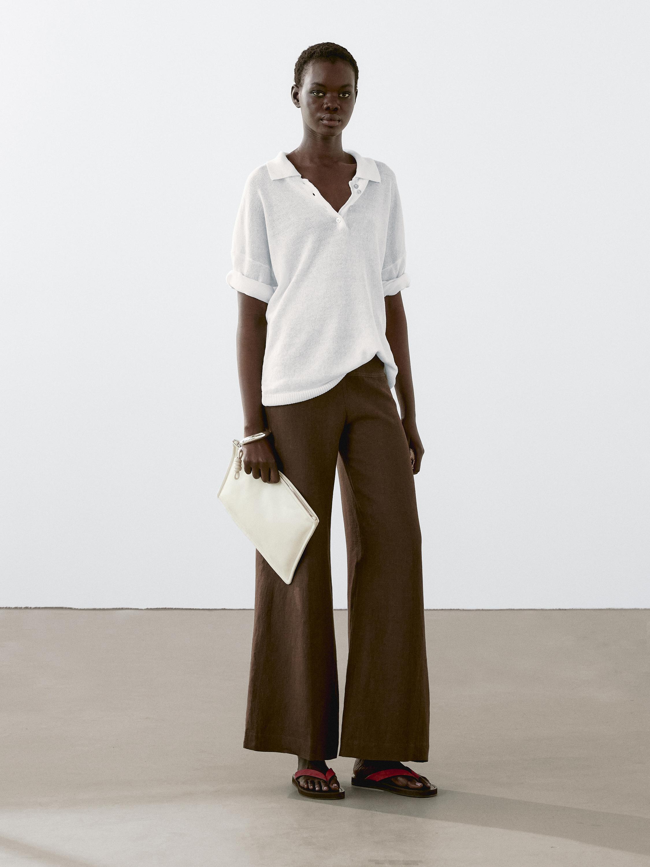 طقم مكون من قميص أبيض بياقة وبنطلون بني واسع من الأسفل.