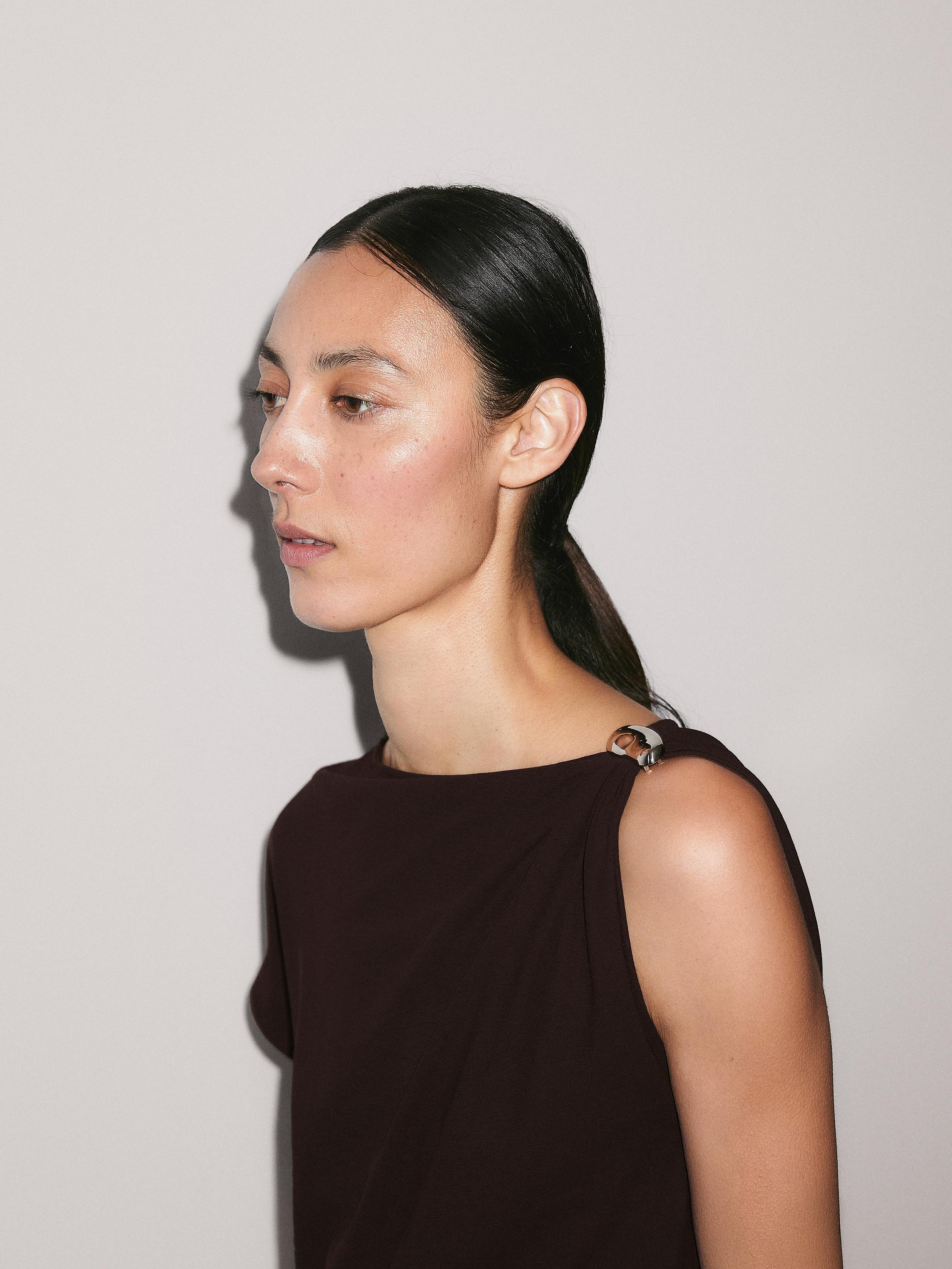 드레이프 네크라인 탑에 브로치 디테일이 있는 상의