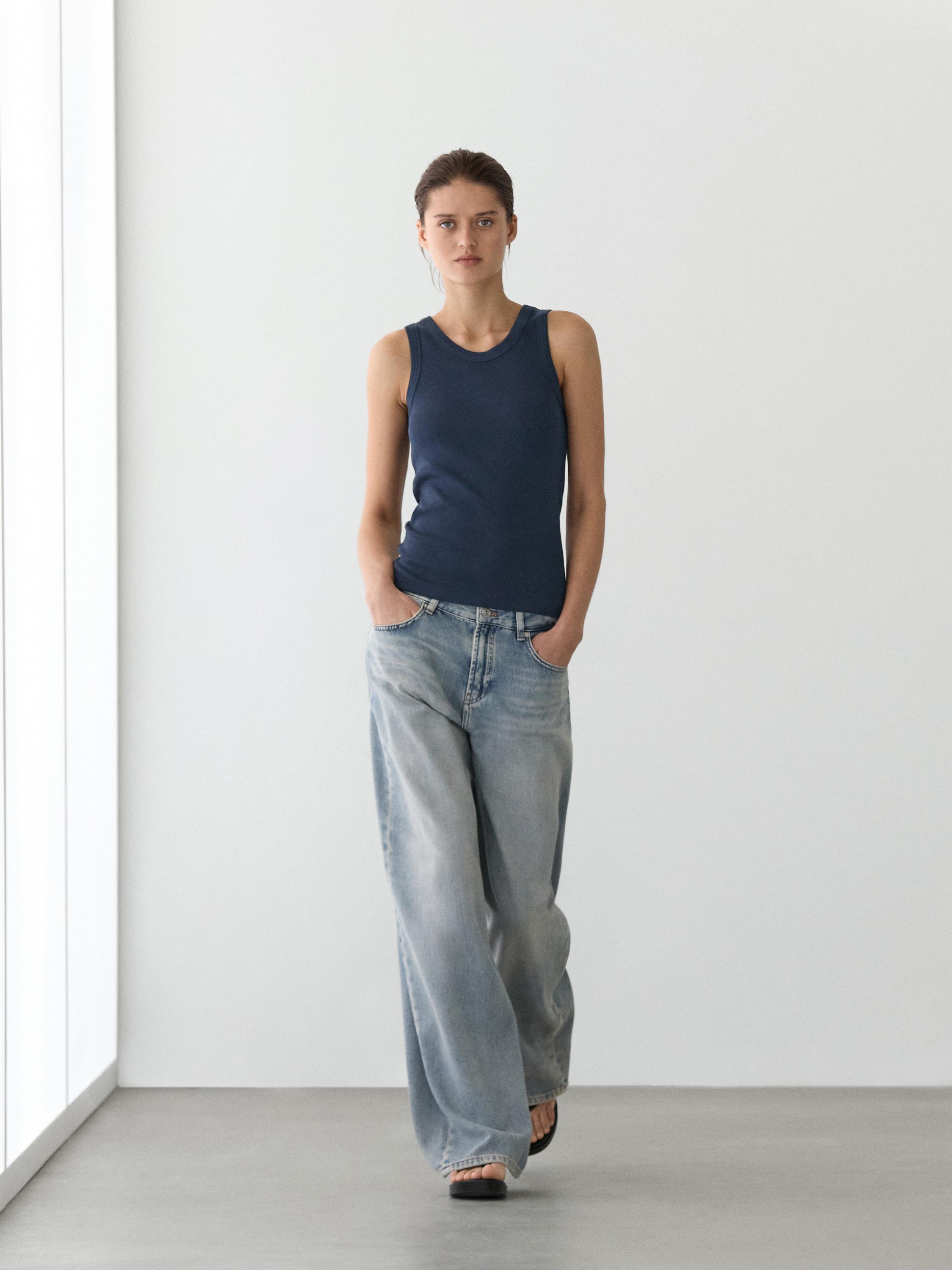 Conjunto de camiseta halter azul marino sin mangas y pantalones de mezclilla anchos de tiro bajo.