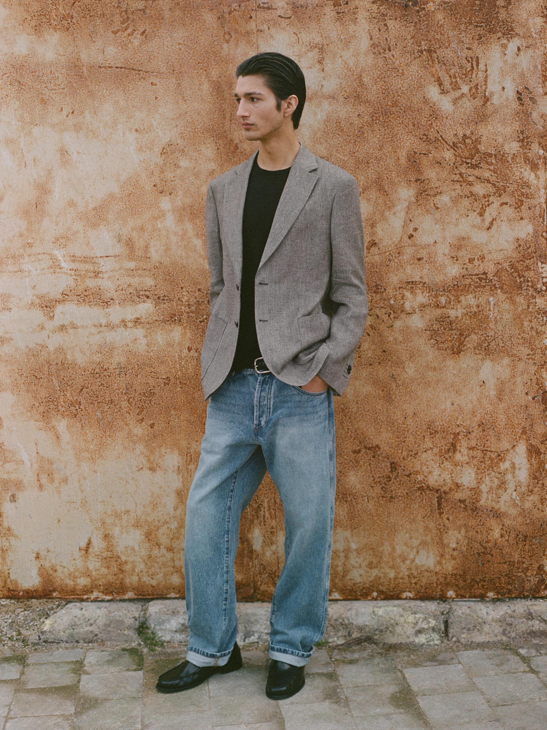 Kombination aus grauem meliertem Blazer mit Taschen und blauen Jeans.