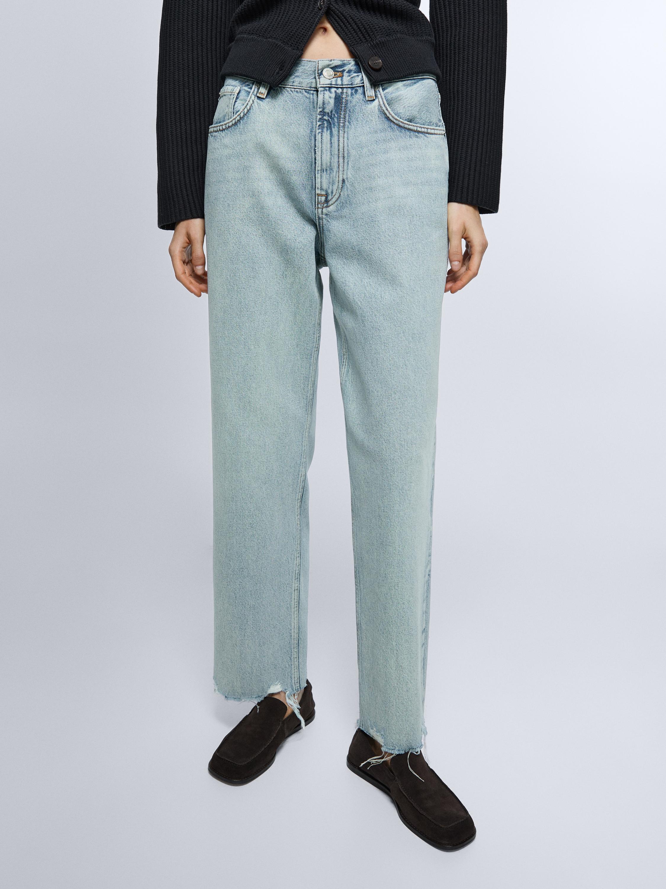 طقم جينز أزرق فاتح بخصر عالٍ، قصة مستقيمة، مع جيوب أمامية وأطراف سفلية مهدبة.