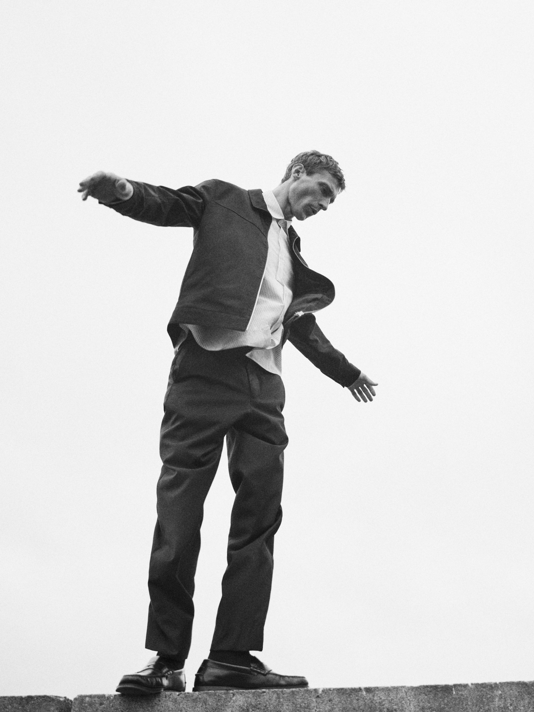 Conjunto de chaqueta oscura, camisa clara y pantalones oscuros.