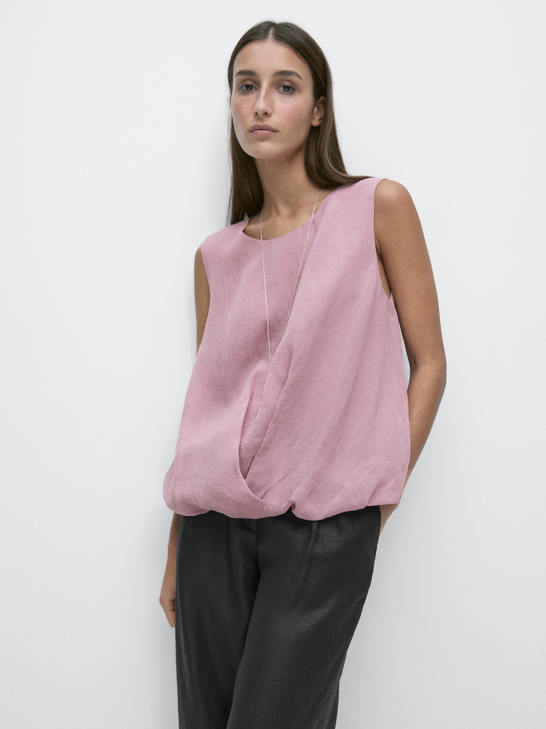 Pink sleeveless top with a front pleat and straight dark pants set.