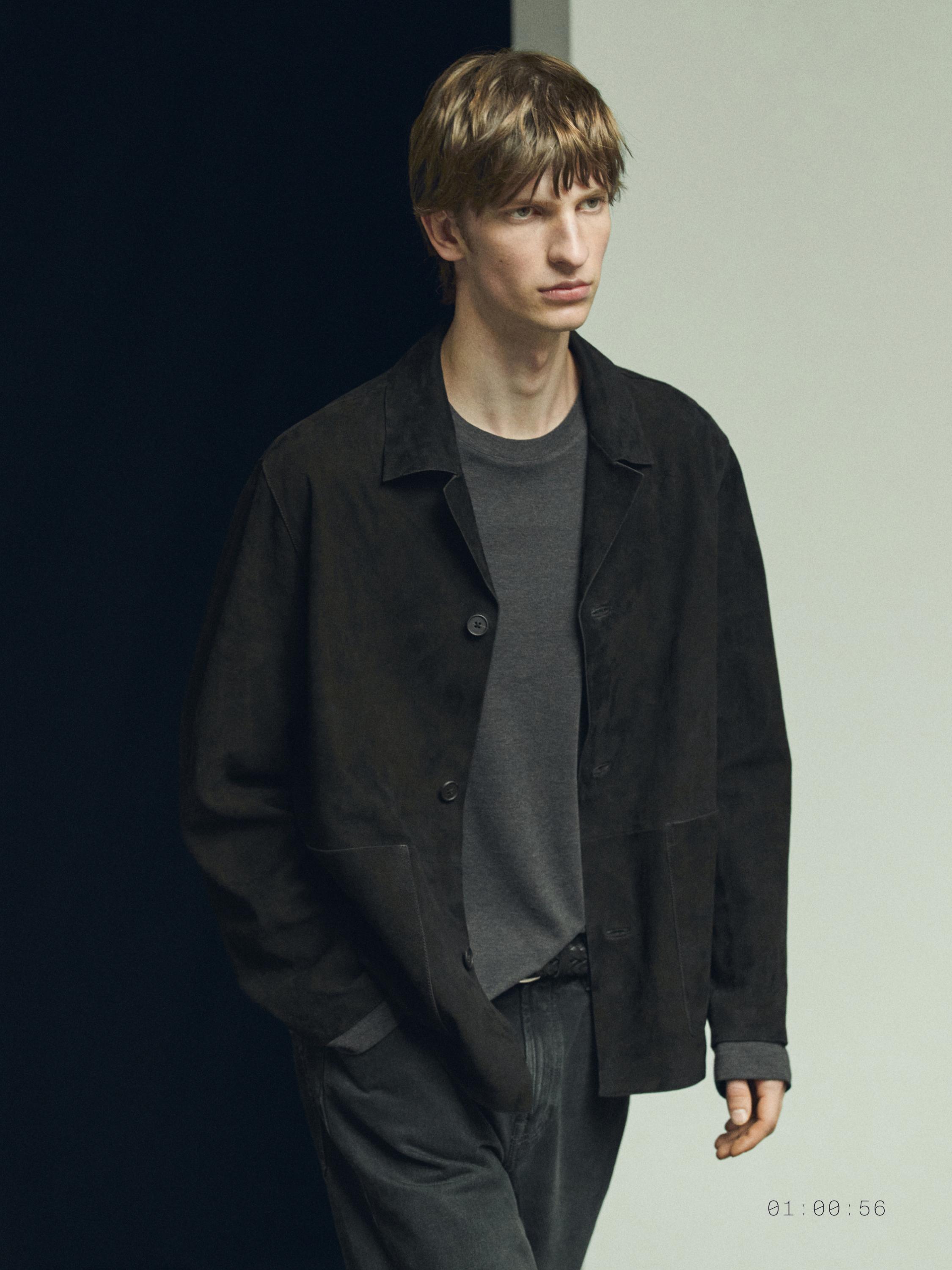 Komplet xhakete e zezë me kopsa dhe bluzë gri.