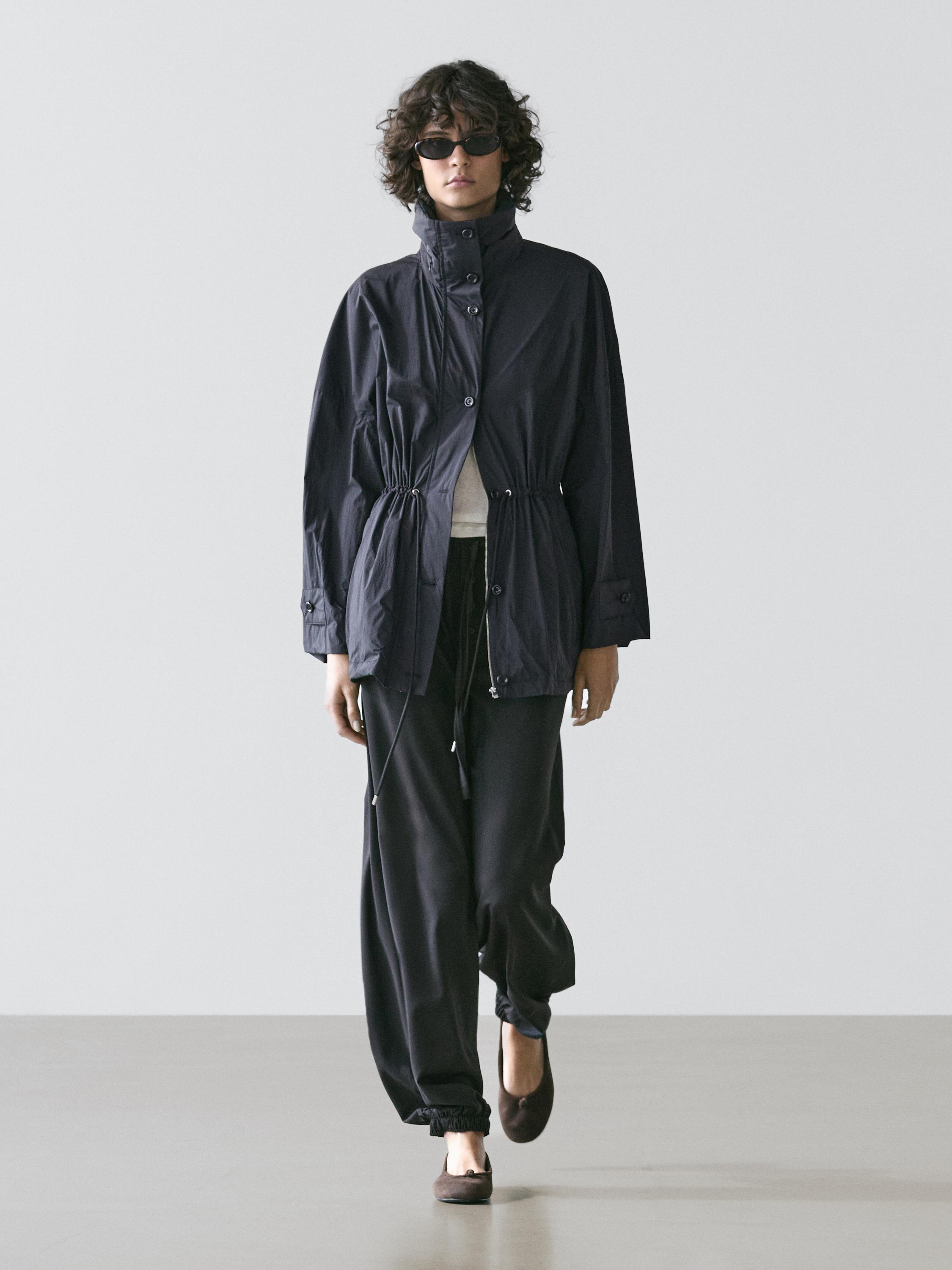 Dark blue parka set with adjustable drawstrings and loose black pants.