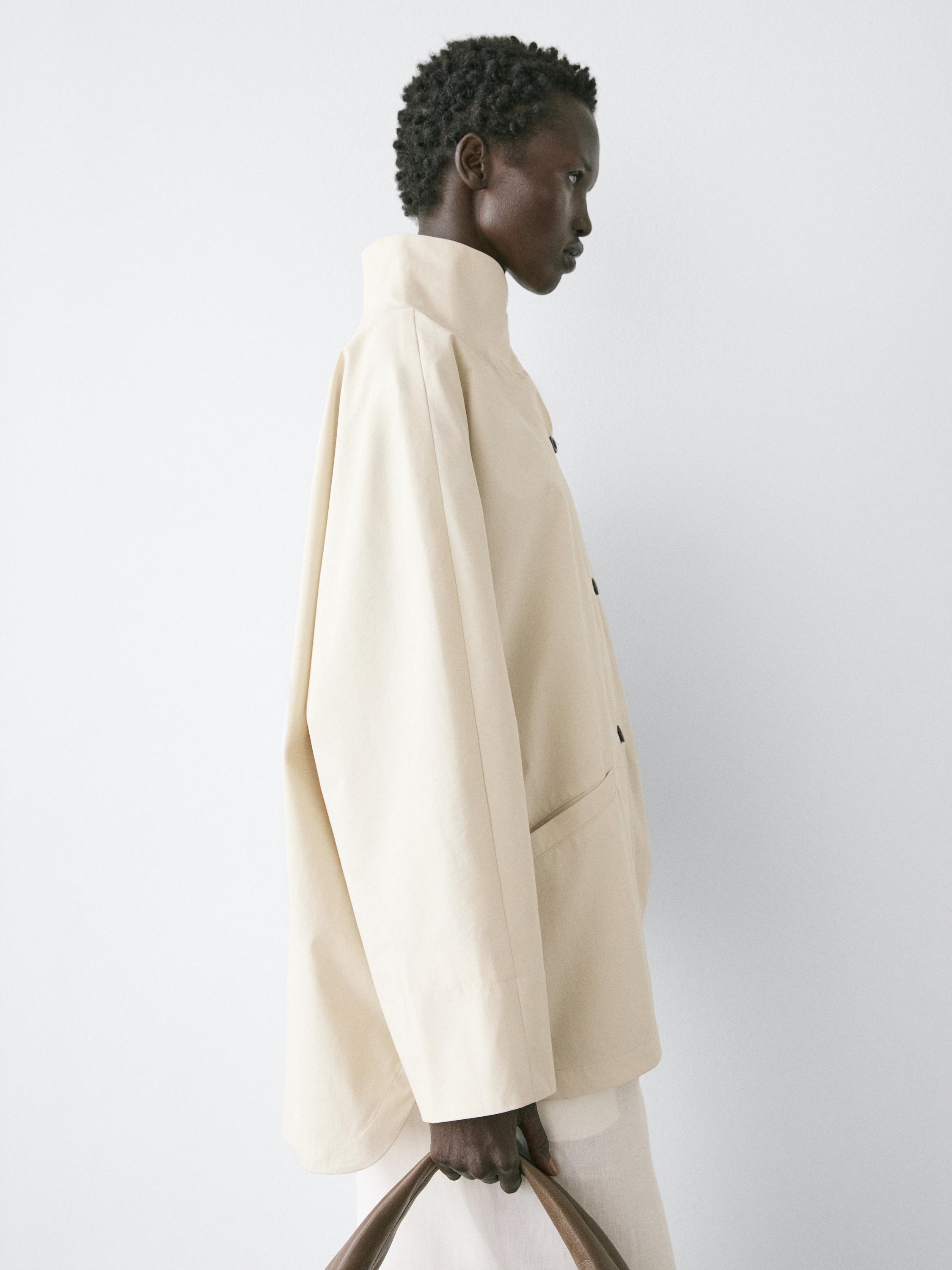 Półzbliżenie surowej kurtki ze stójką i bocznymi kieszeniami.