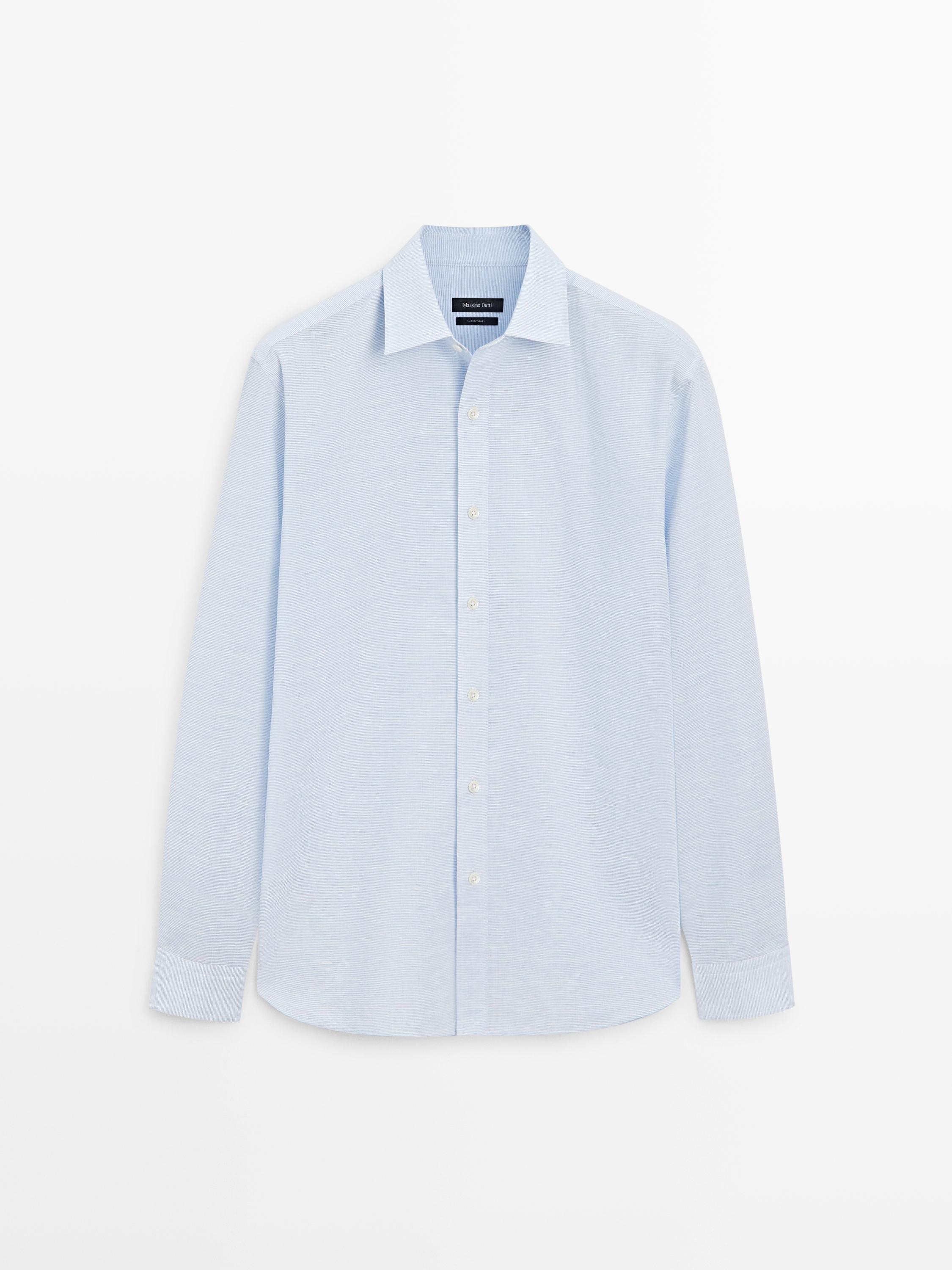 Vista frontal de camisa azul celeste de manga comprida, corte regular, com gola clássica e abotoadura central.