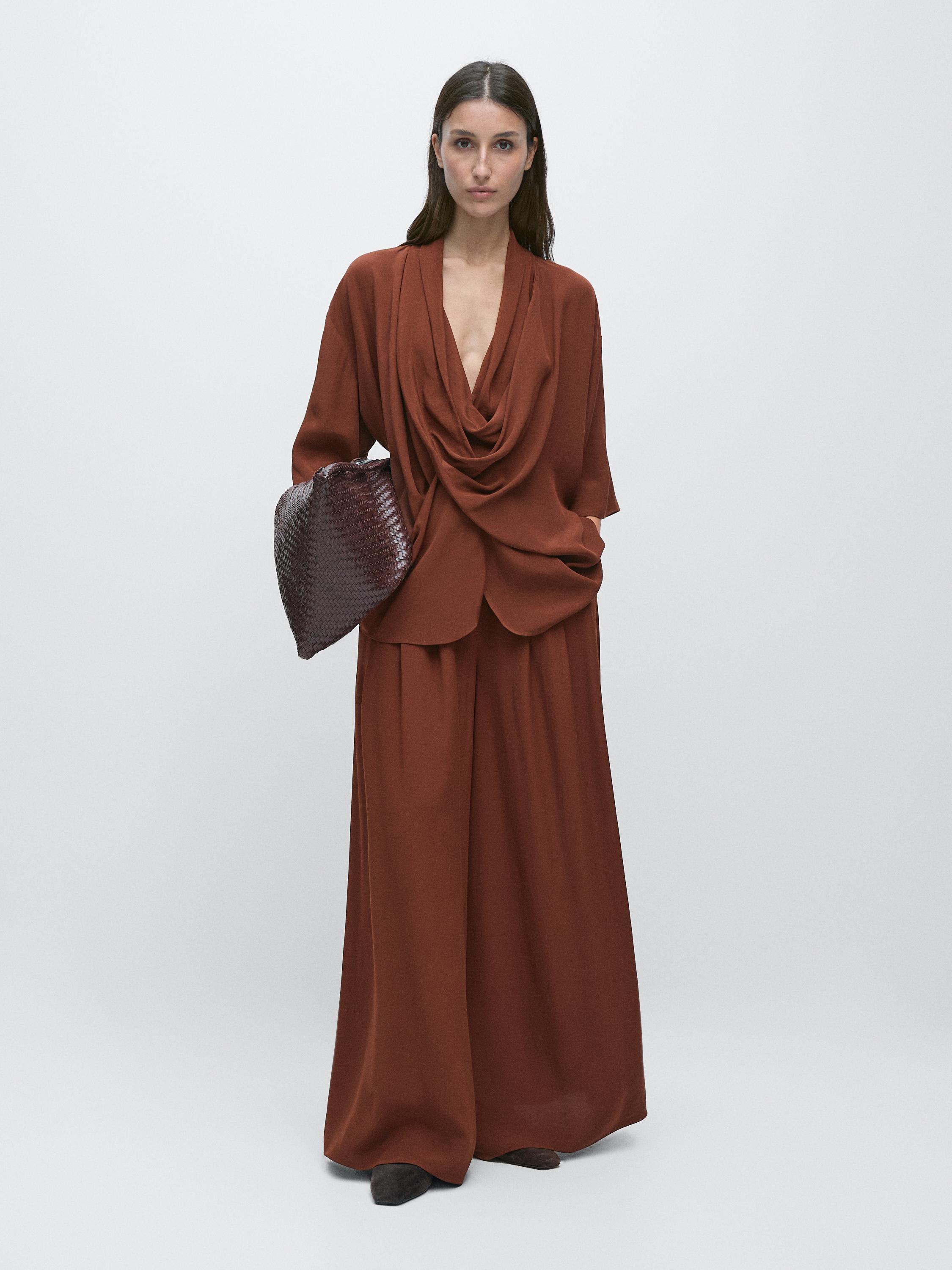 طقم قميص برتقالي بياقة مكشكشة وبنطلون واسع متناسق.