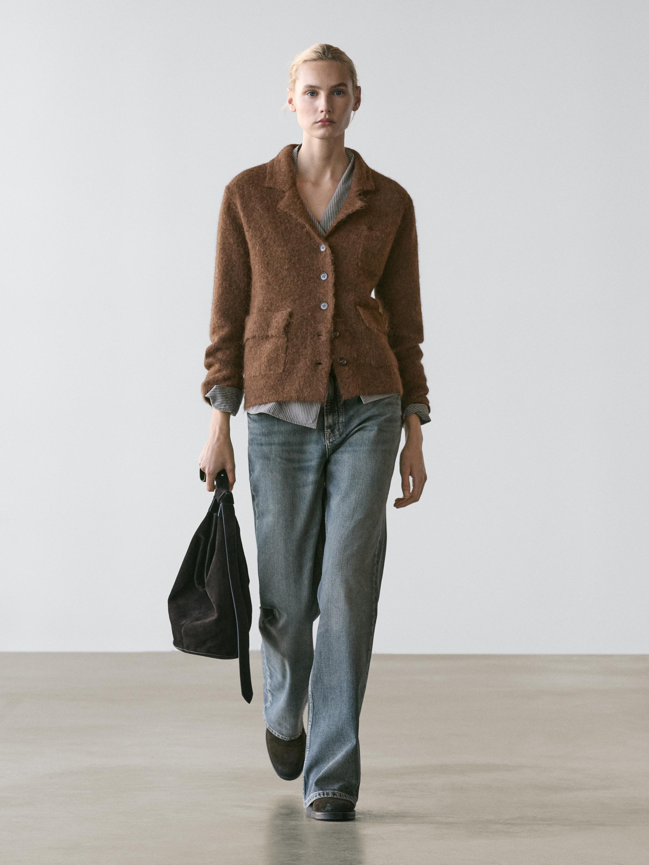 Toasted cardigan set with front pockets and buttons, gray shirt, blue jeans, and black purse.