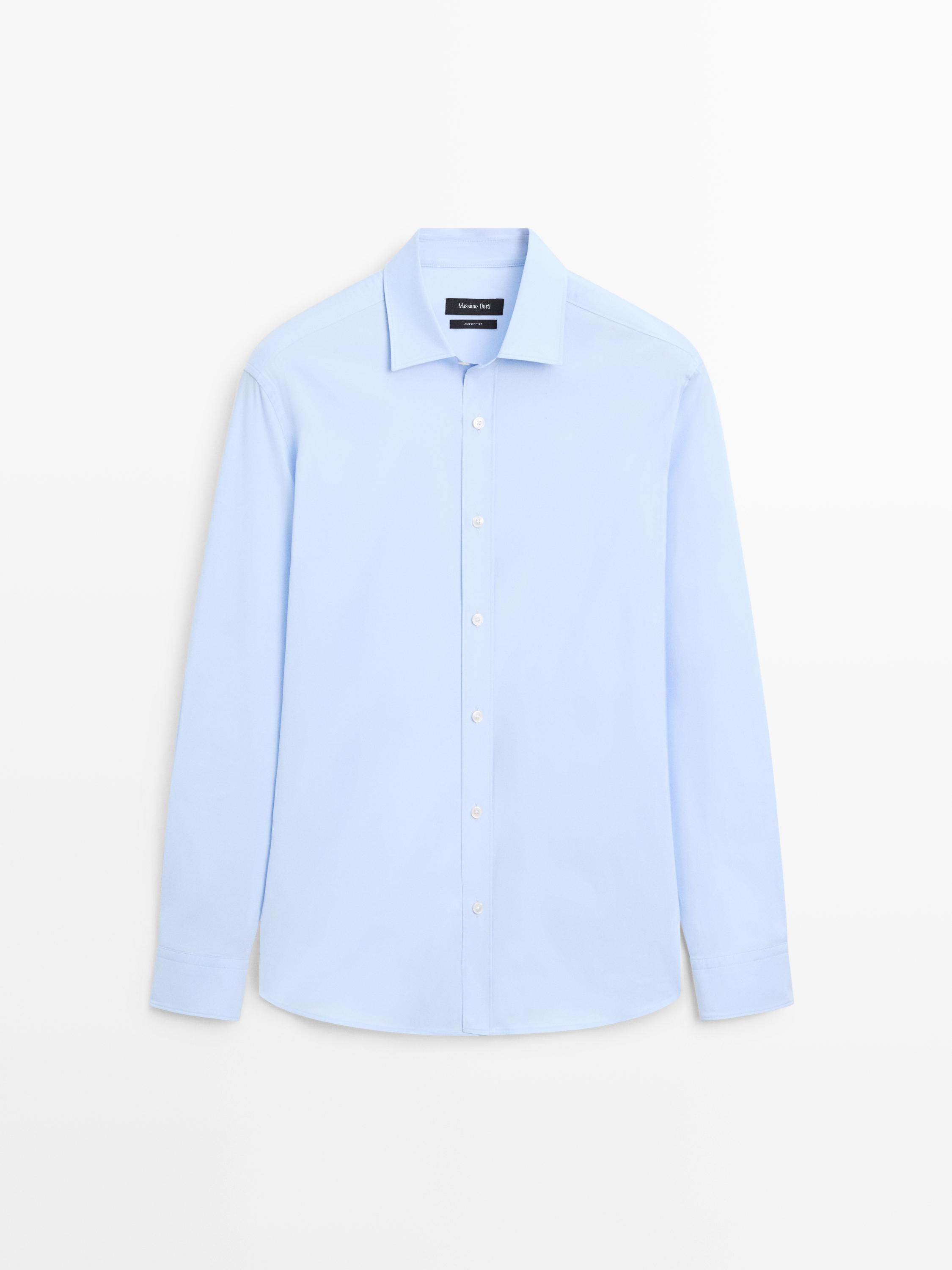 Vista frontal de camisa azul celeste de manga comprida com botões centrais e gola clássica.