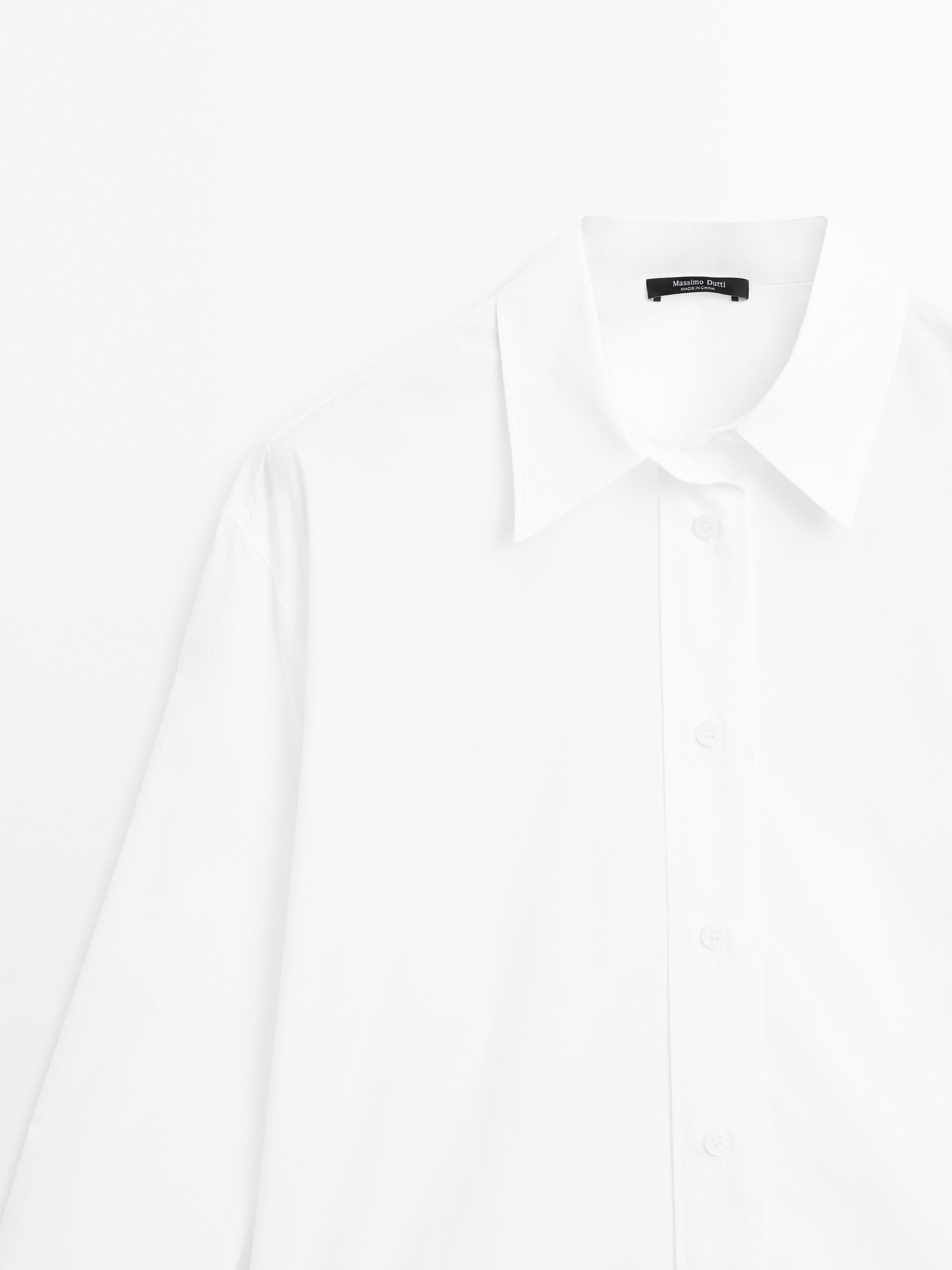 Plan moyen de chemise blanche à col classique et patte de boutonnage frontale.