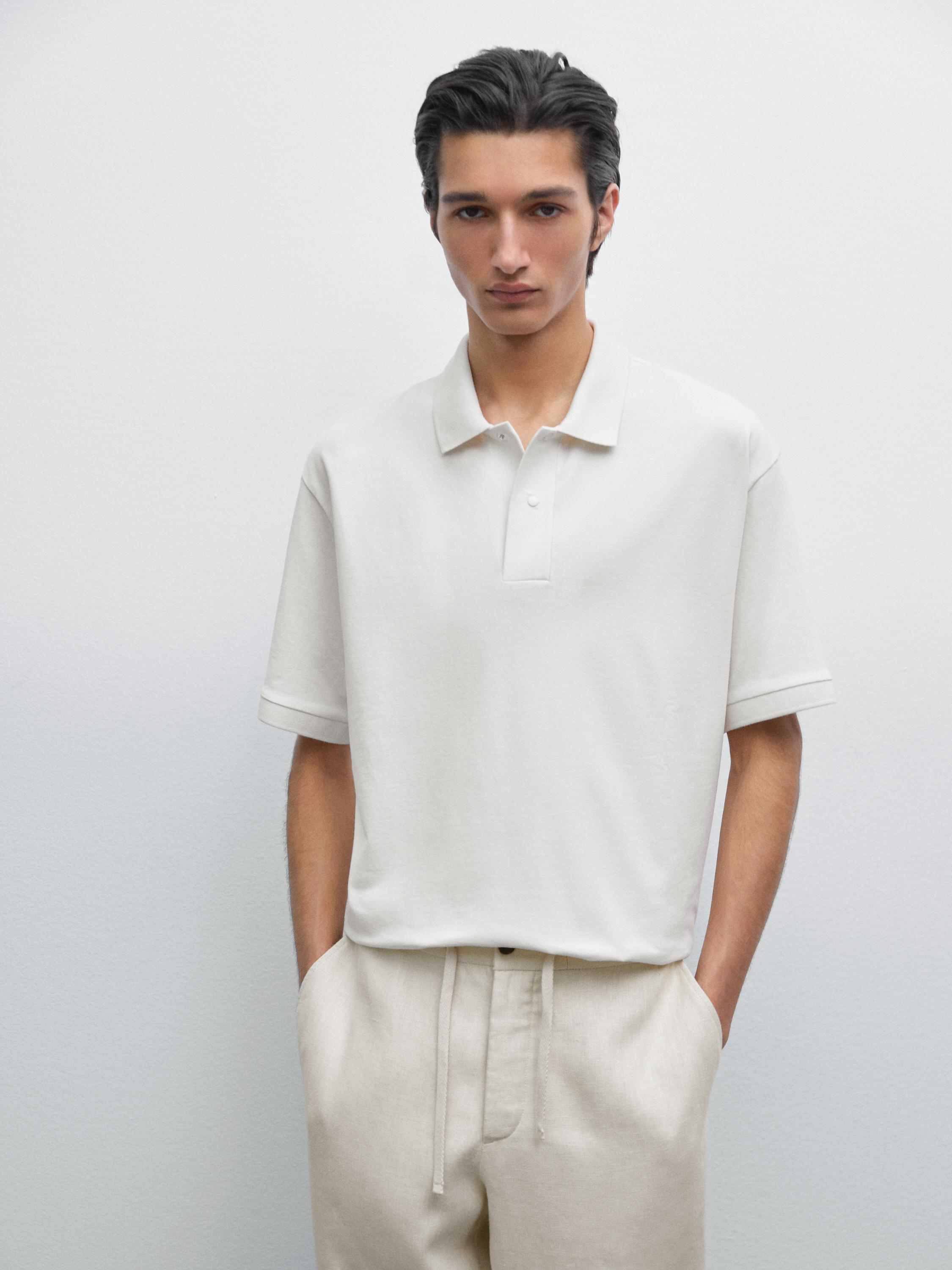 Conjunto de polo blanco de manga corta con cuello y pantalones beige con cordón.