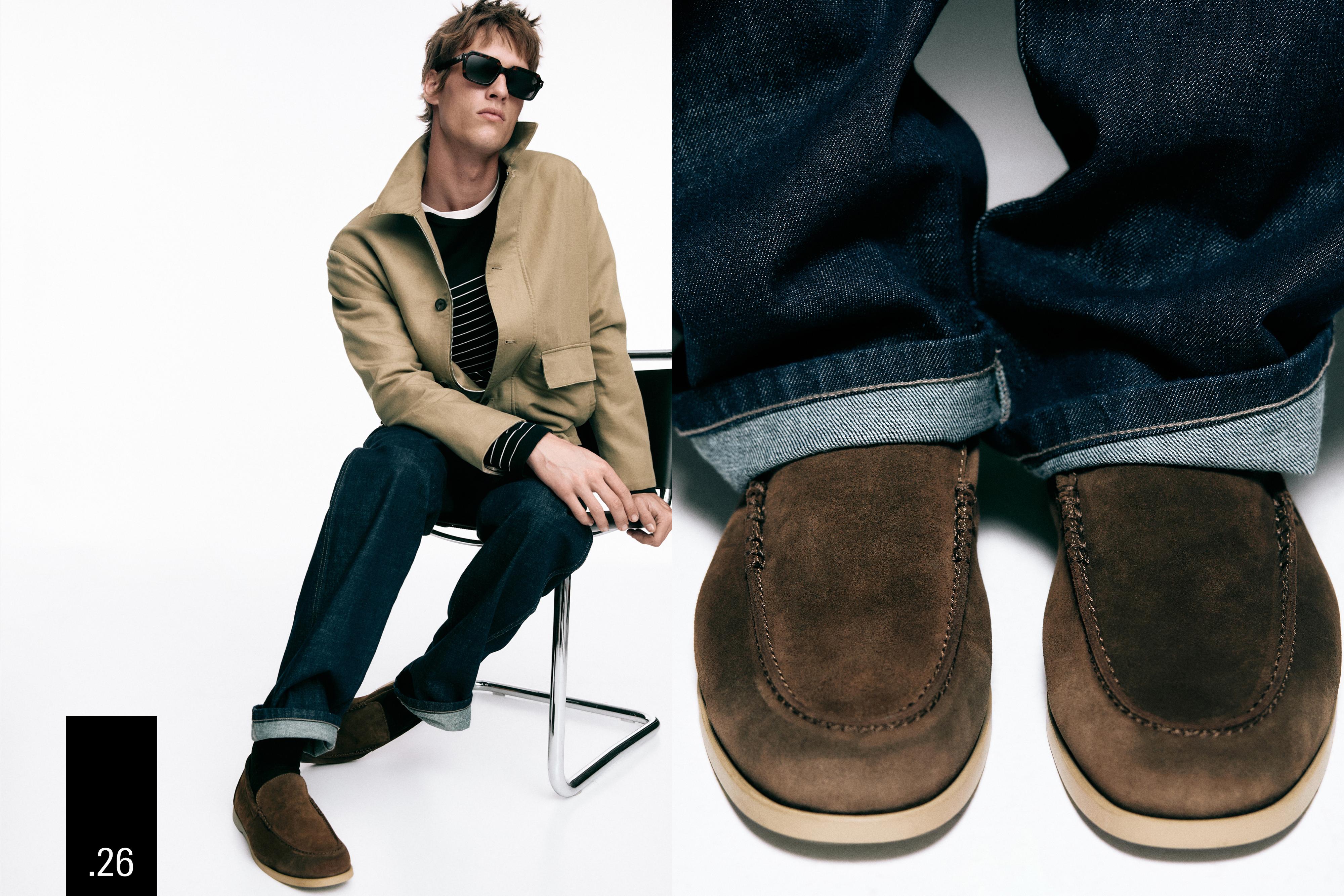 Komplet me xhaketë bezhë, bluzë me vija të zeza, xhinse të errëta me palë dhe mokasina kafe.