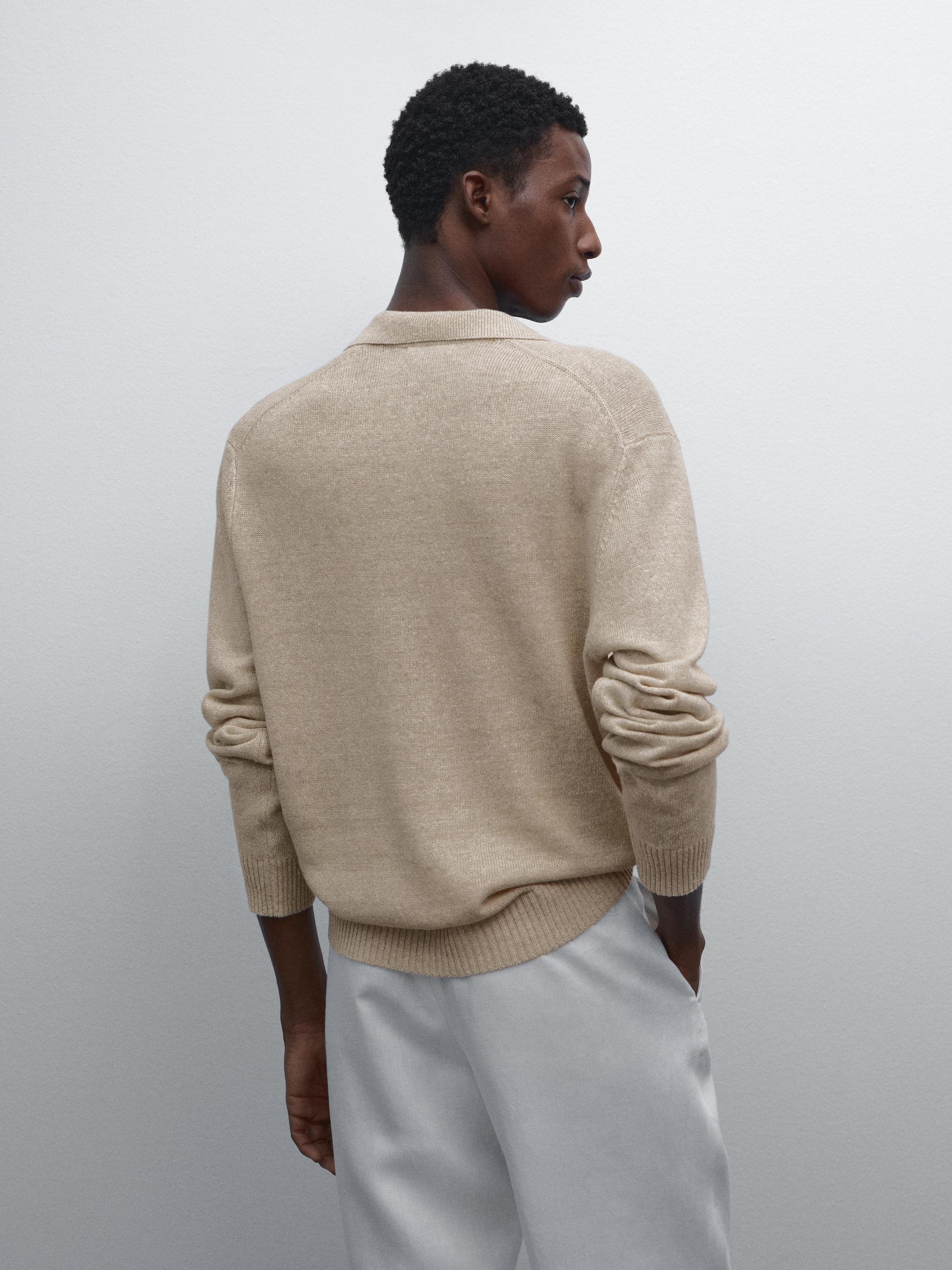 Vue arrière d'un pull beige avec col et poignets côtelés.