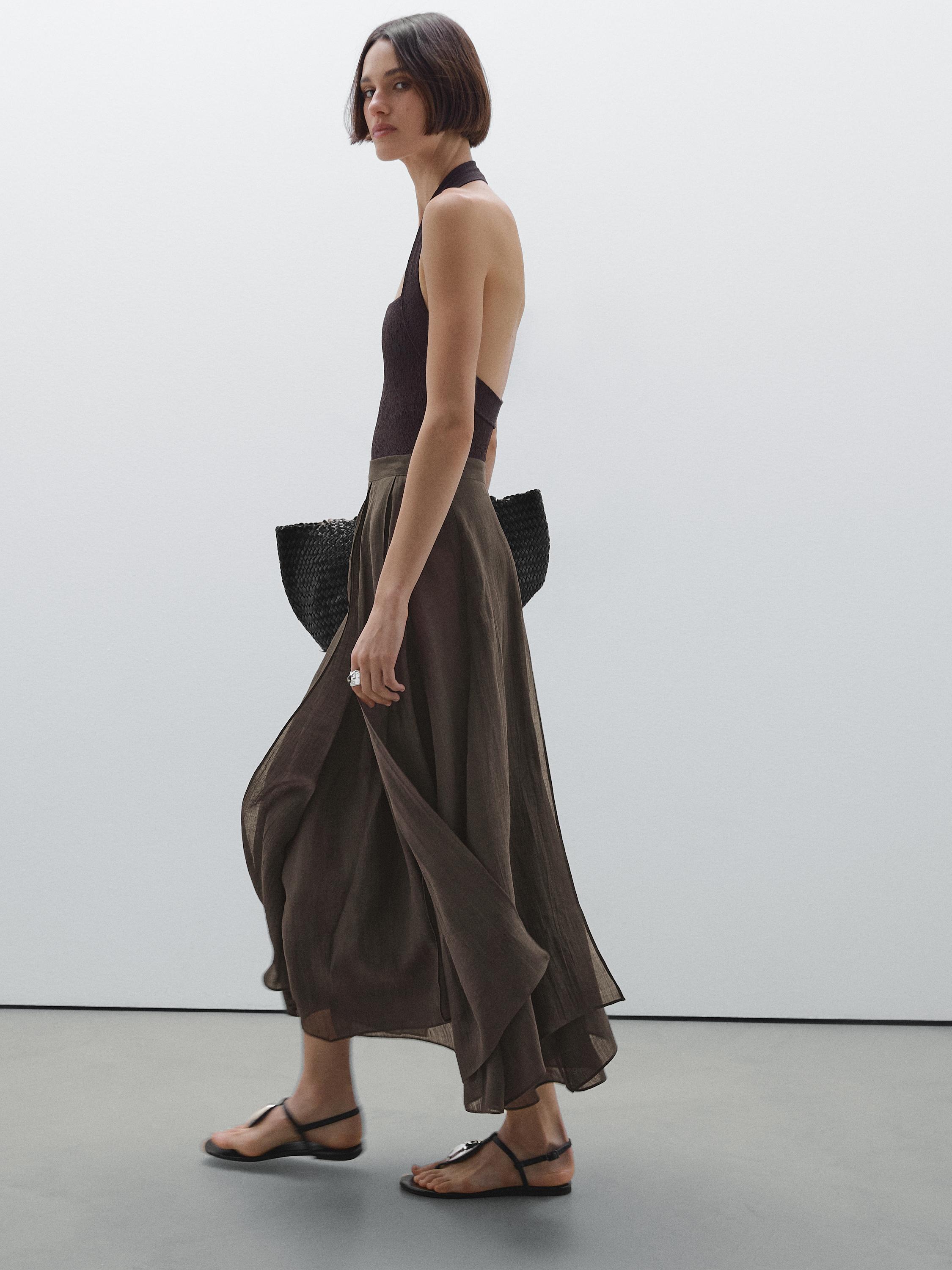 Ensemble composé d'un top dos nu marron et d'une jupe longue fluide marron, sandales noires.