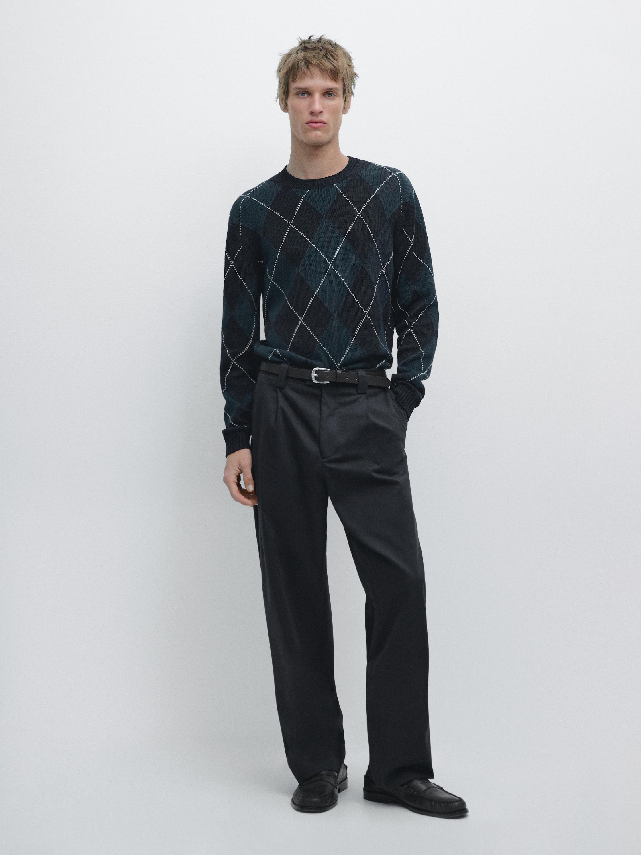 Levanduľový džersejový komplet s kosoštvorcovým vzorom a čierne nohavice rovného strihu s opaskom.