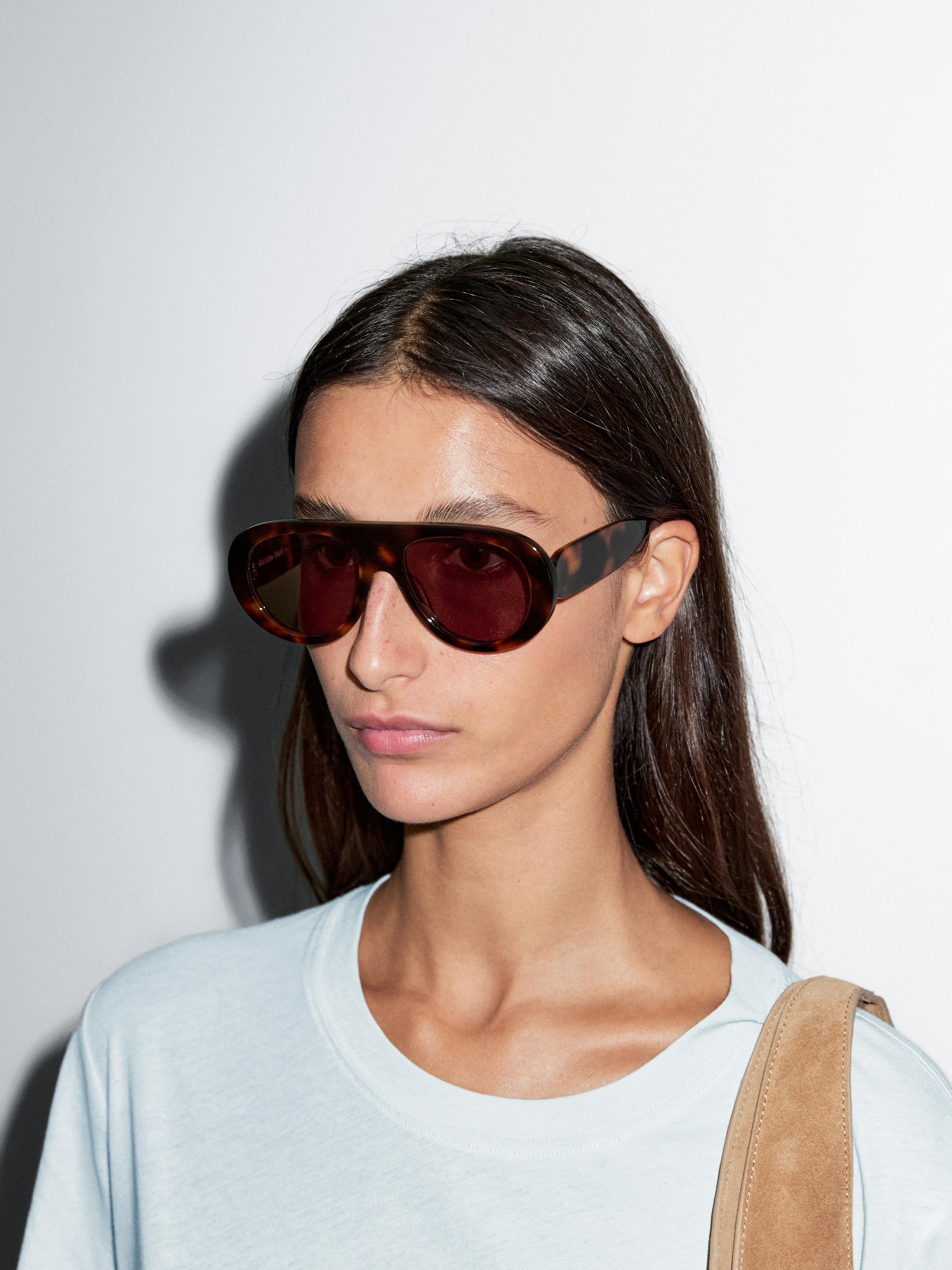 Primer plano de camiseta blanca de manga corta con detalle de costura en el hombro.