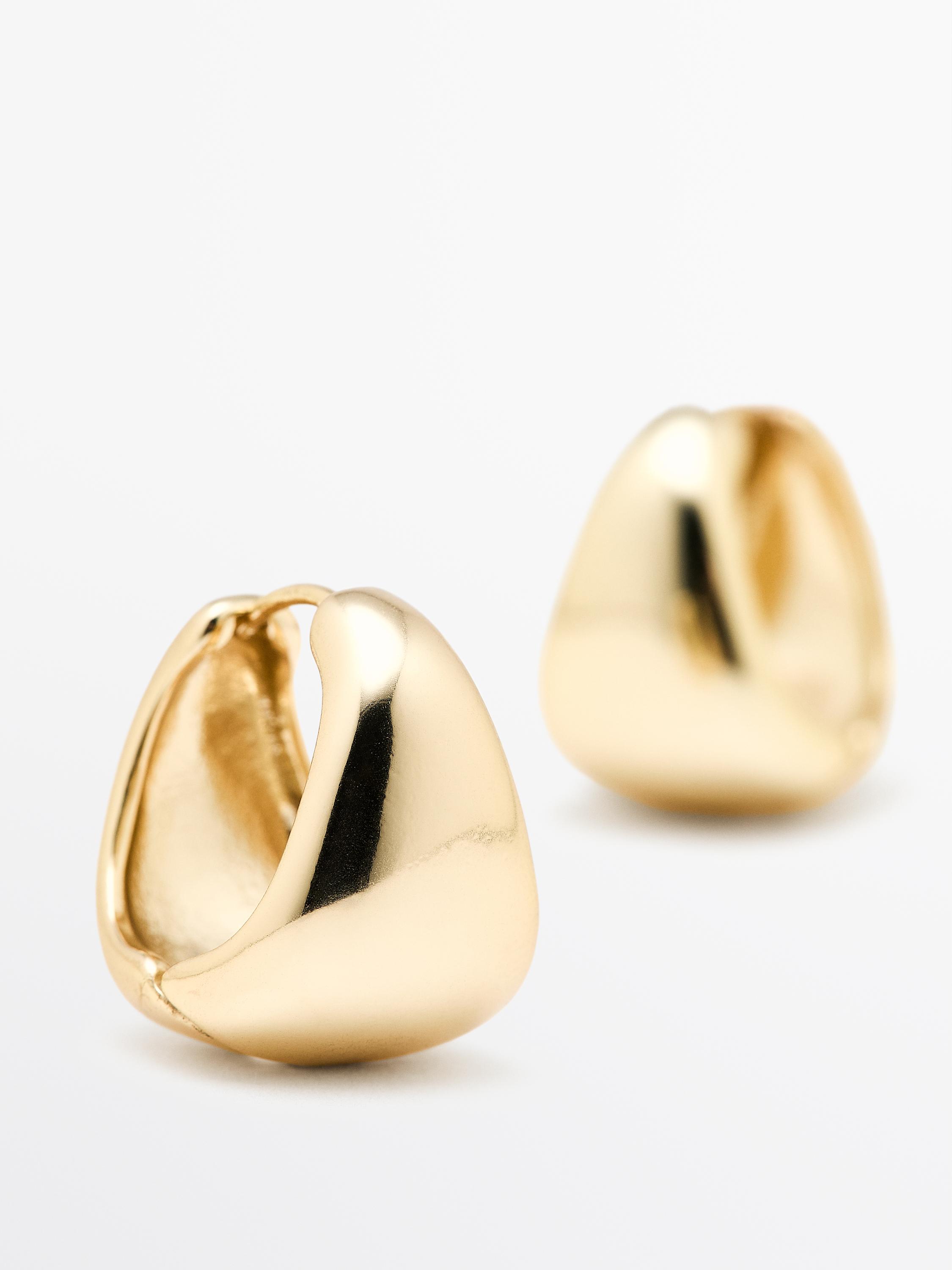 Gouden oorbellen met gebogen design en glanzende afwerking.