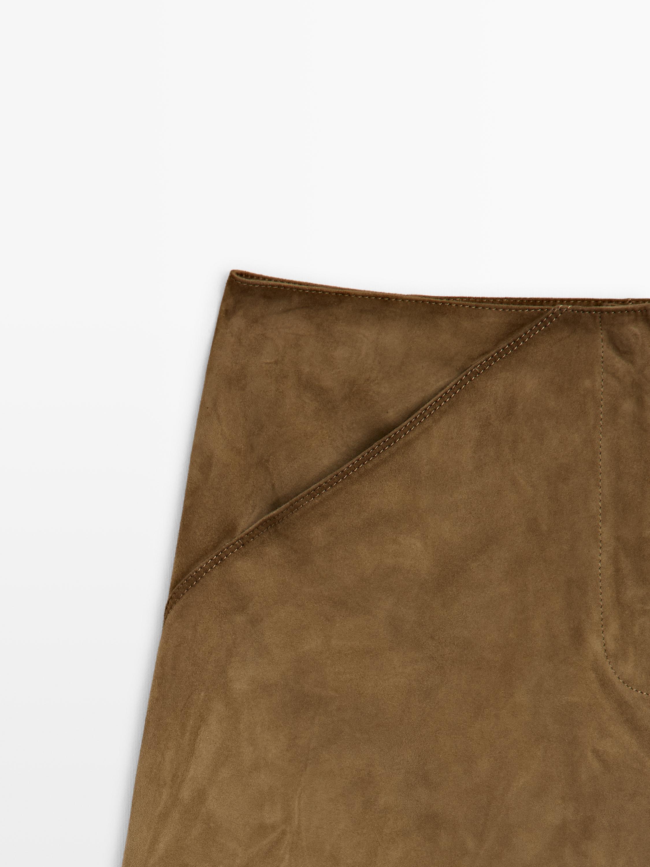 Detail der Oberseite eines kamelfarbenen Minirocks mit sichtbaren Nähten und asymmetrischem Design.