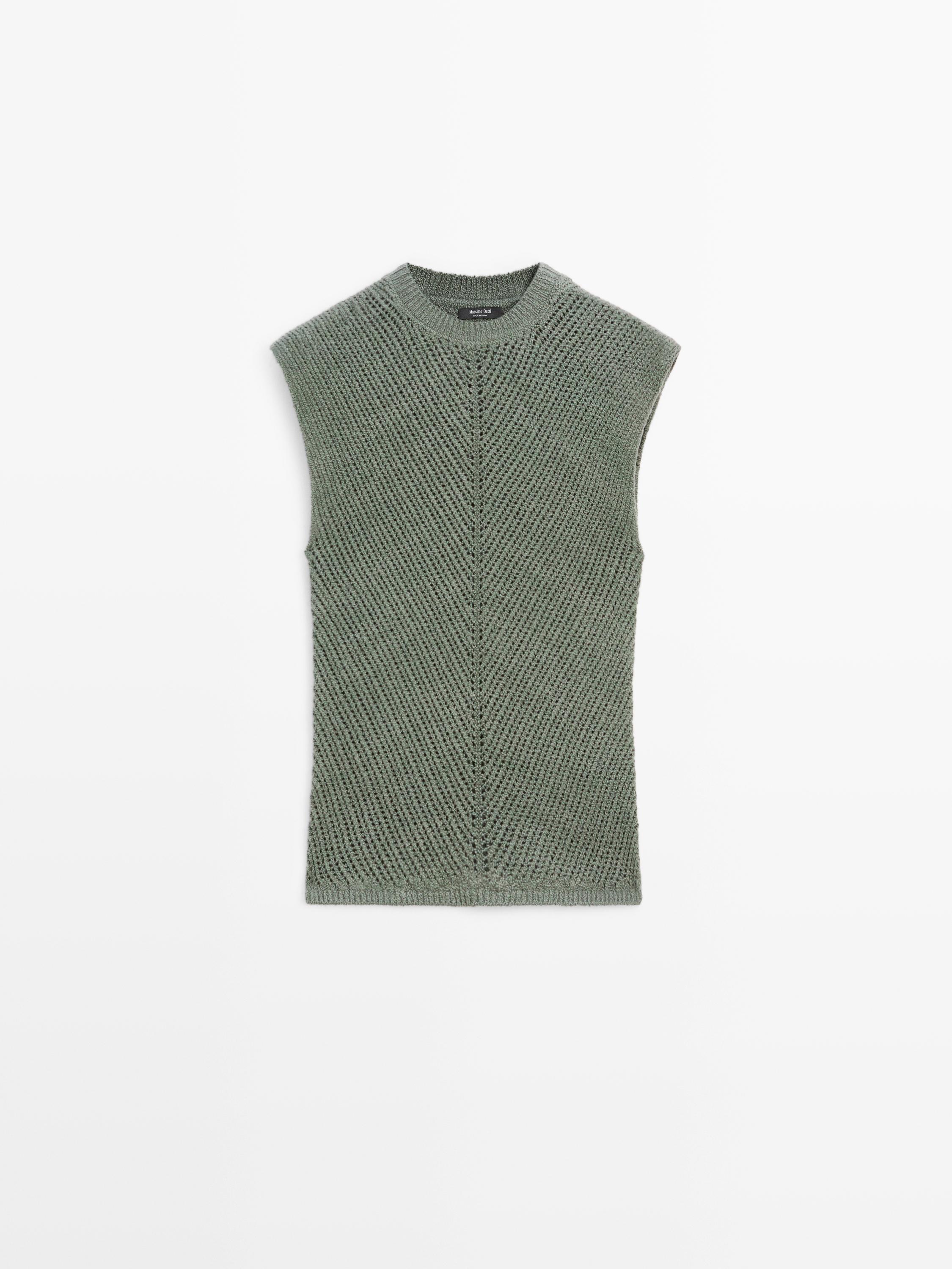 Vista frontal de top sin mangas verde azulado con detalles de calado y cuello redondo.