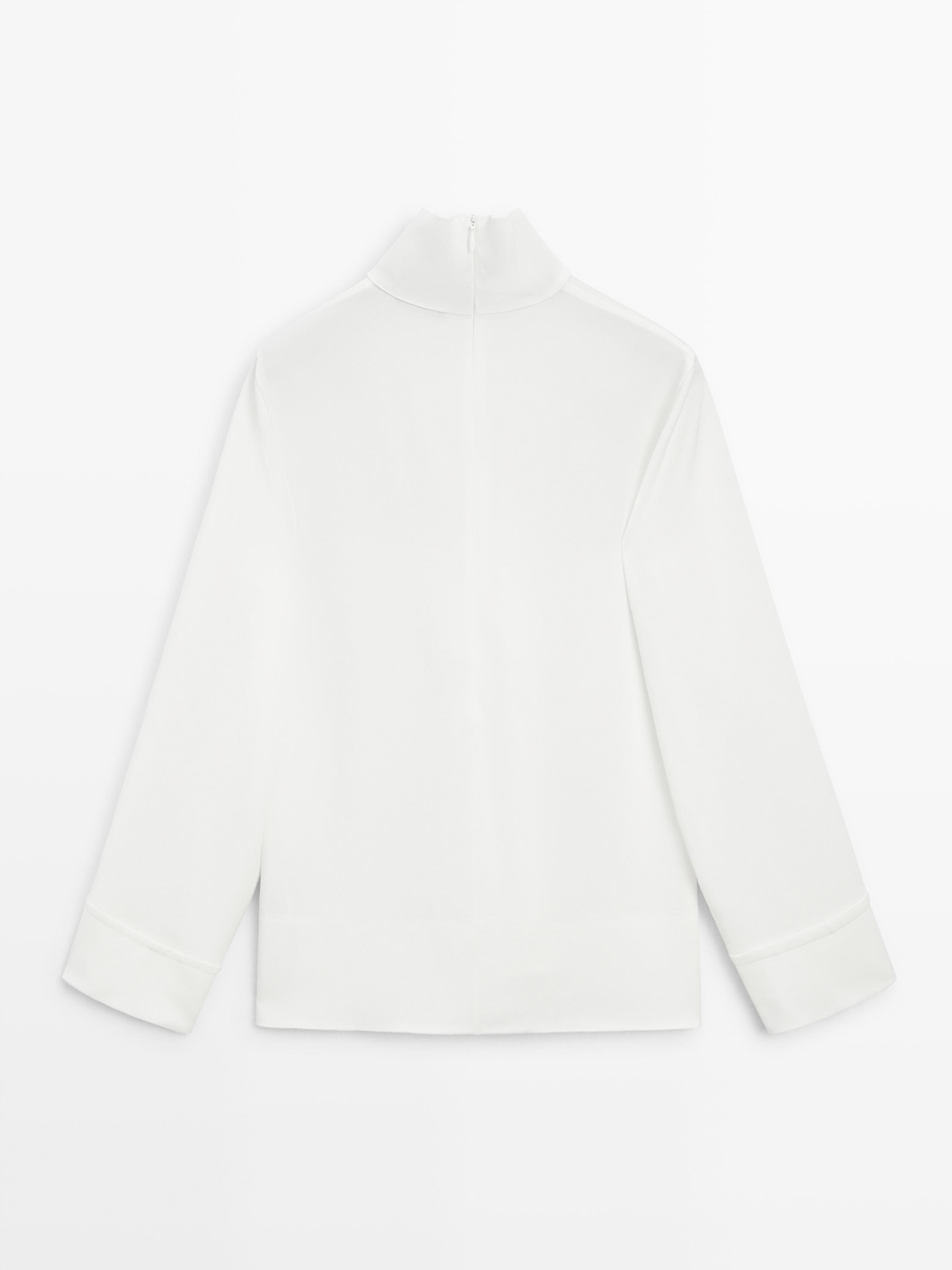 Blusa cuello subido detalle bajo