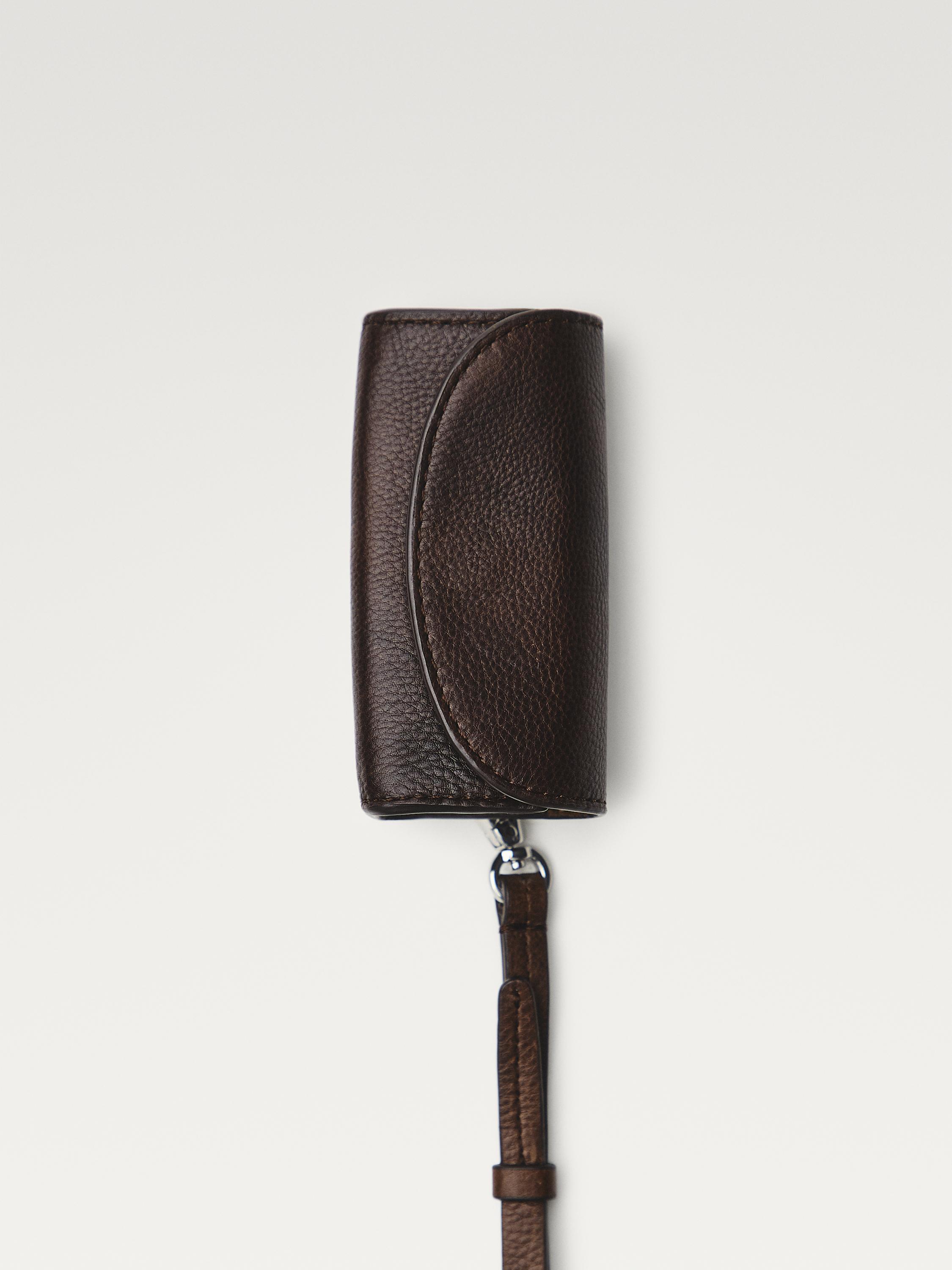 Vista frontal de moneder xocolata amb tancament corbat i corretja desmuntable.