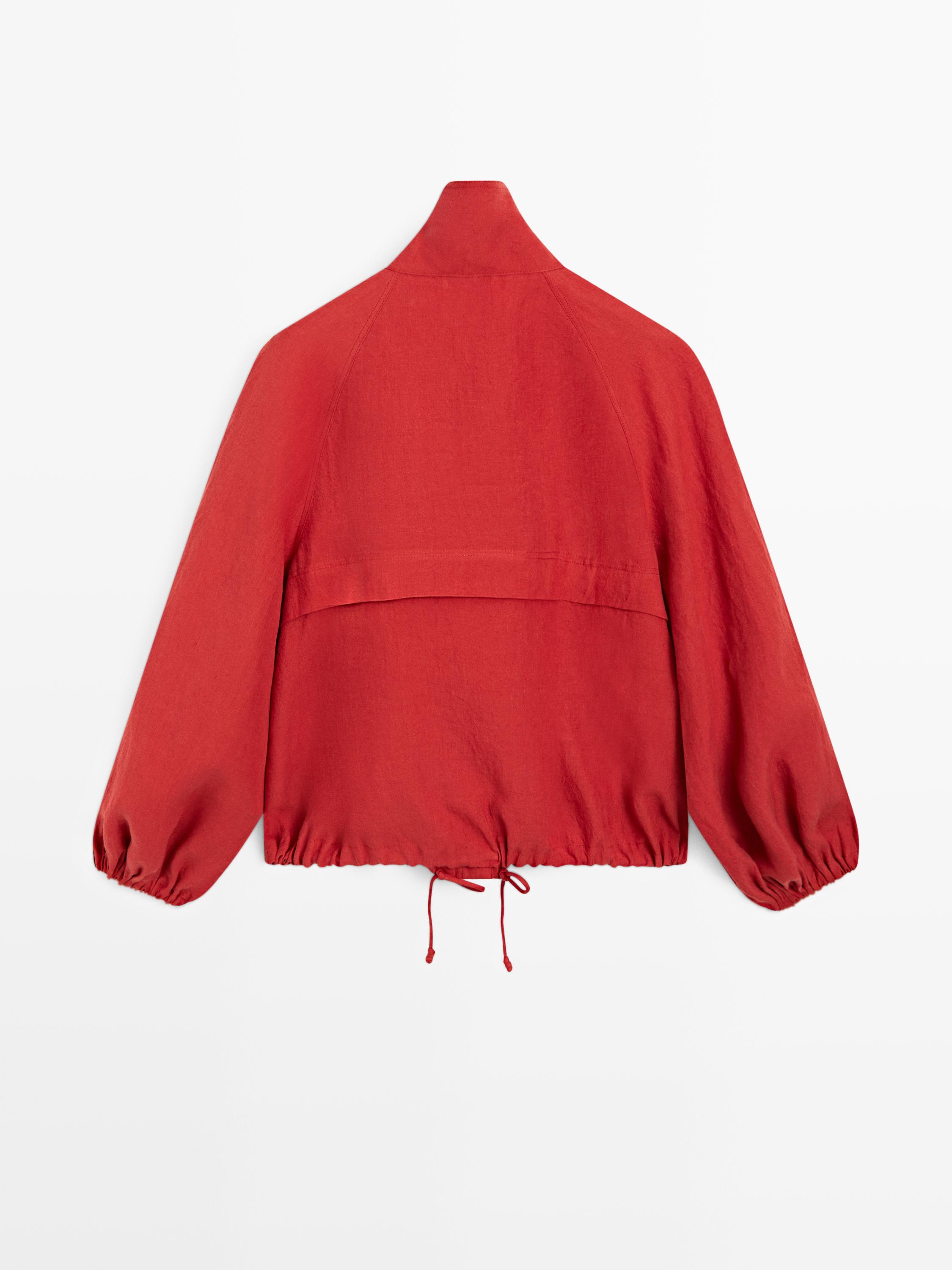 Rear view of a puffy orange bomber jacket with long sleeves and an adjustable drawstring hem.