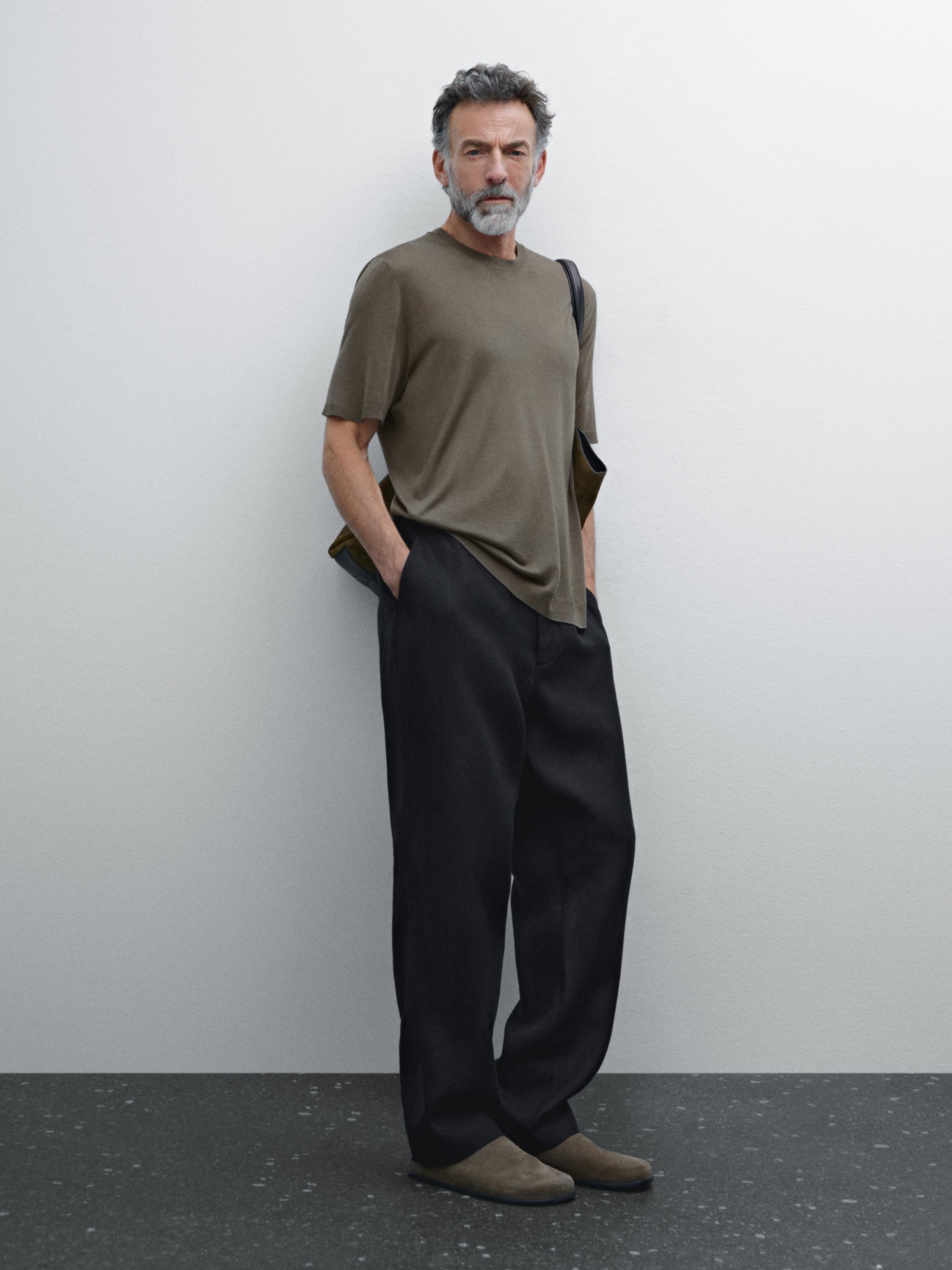 Conjunto de camiseta marrón y pantalones negros amplios.