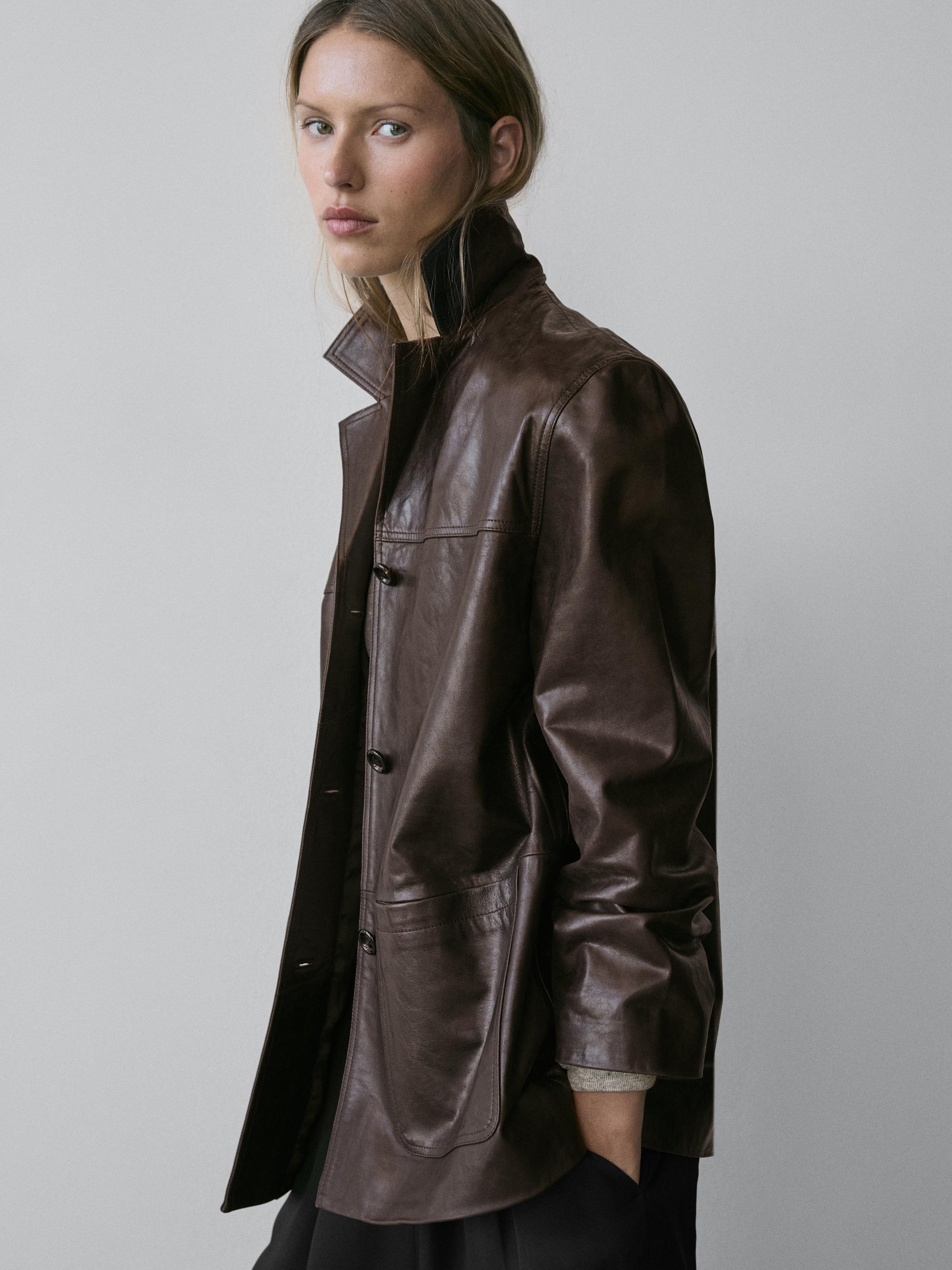 Plano medio de chaqueta marrón con botones y bolsillos laterales.