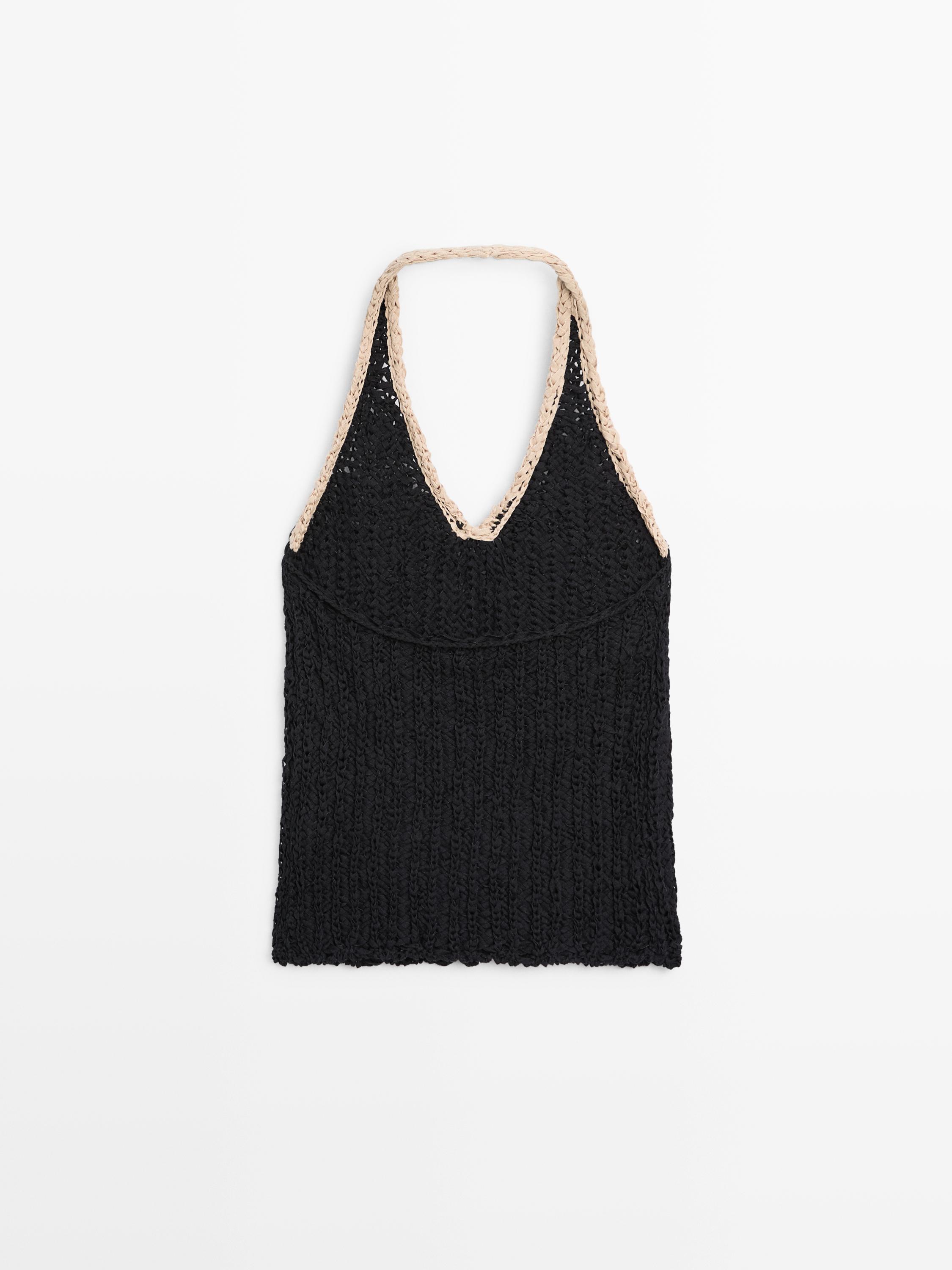 Vista frontal de top negro de tricot con escote halter y borde beige.
