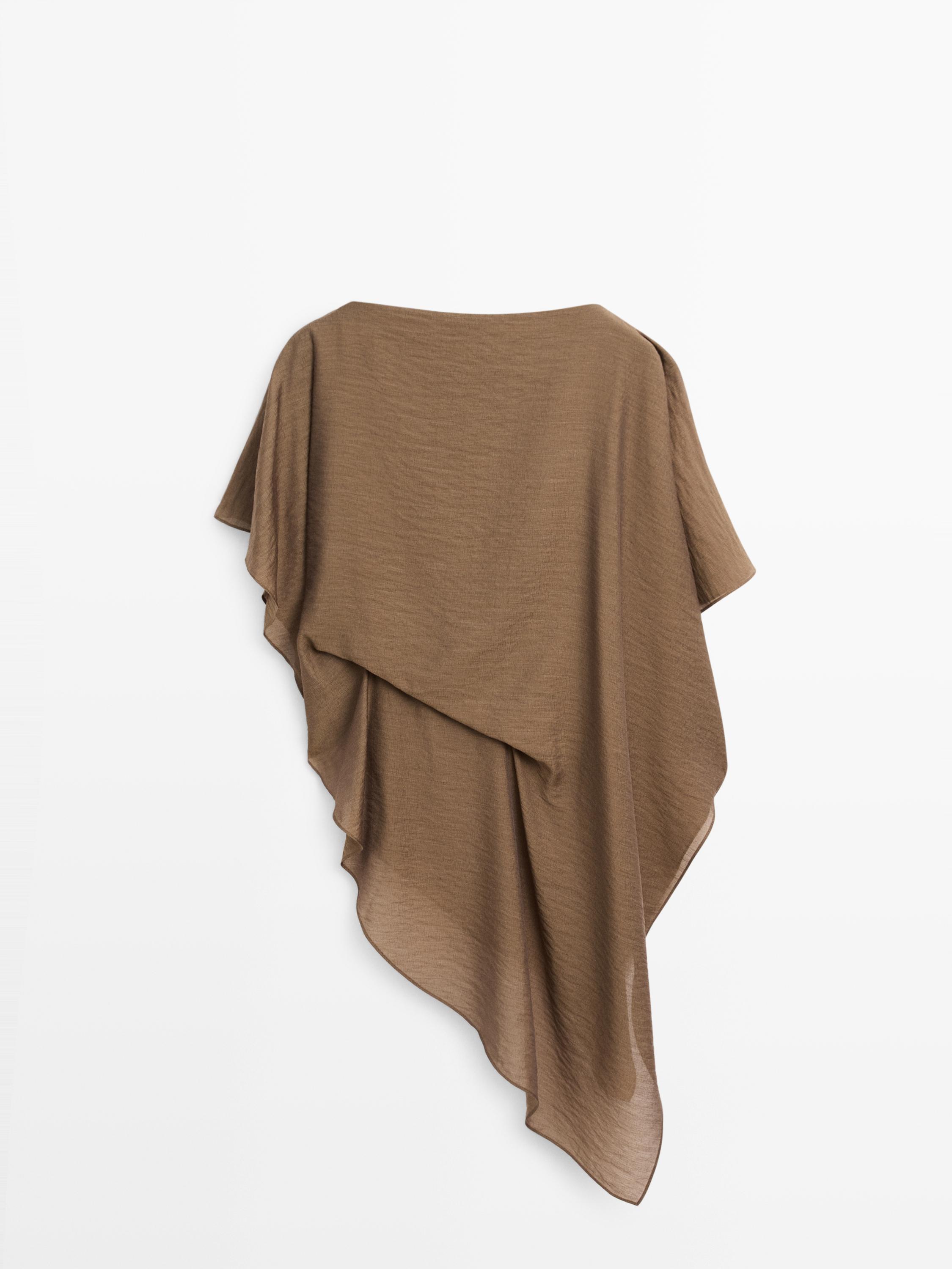Rear view of a khaki blouse with an asymmetrical design and fluid drape.