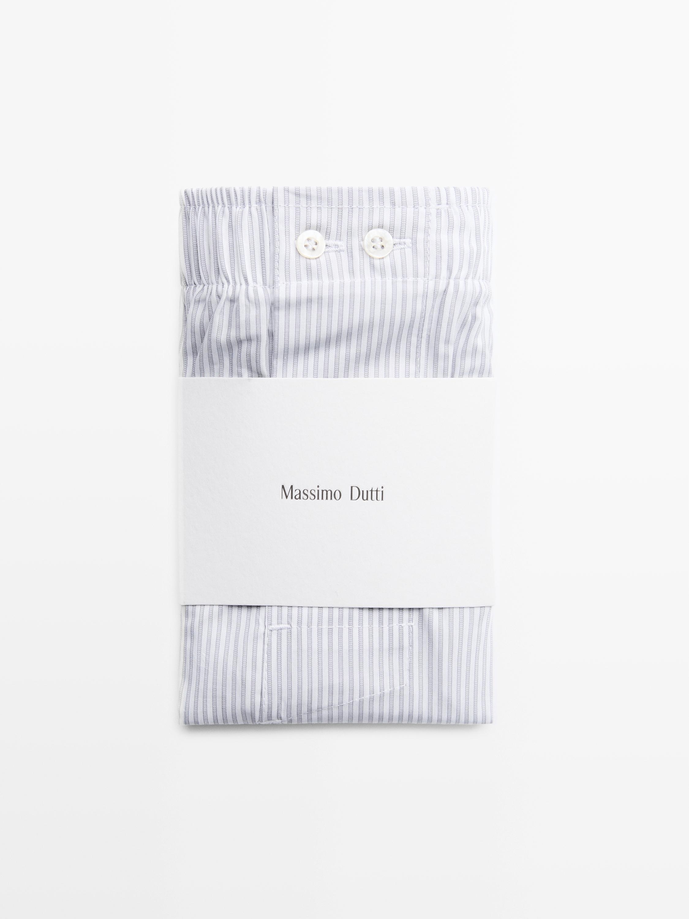 Krupan plan sivih prugastih gaćica sa dugmadima napred i tekstom "Massimo Dutti" na pakovanju.