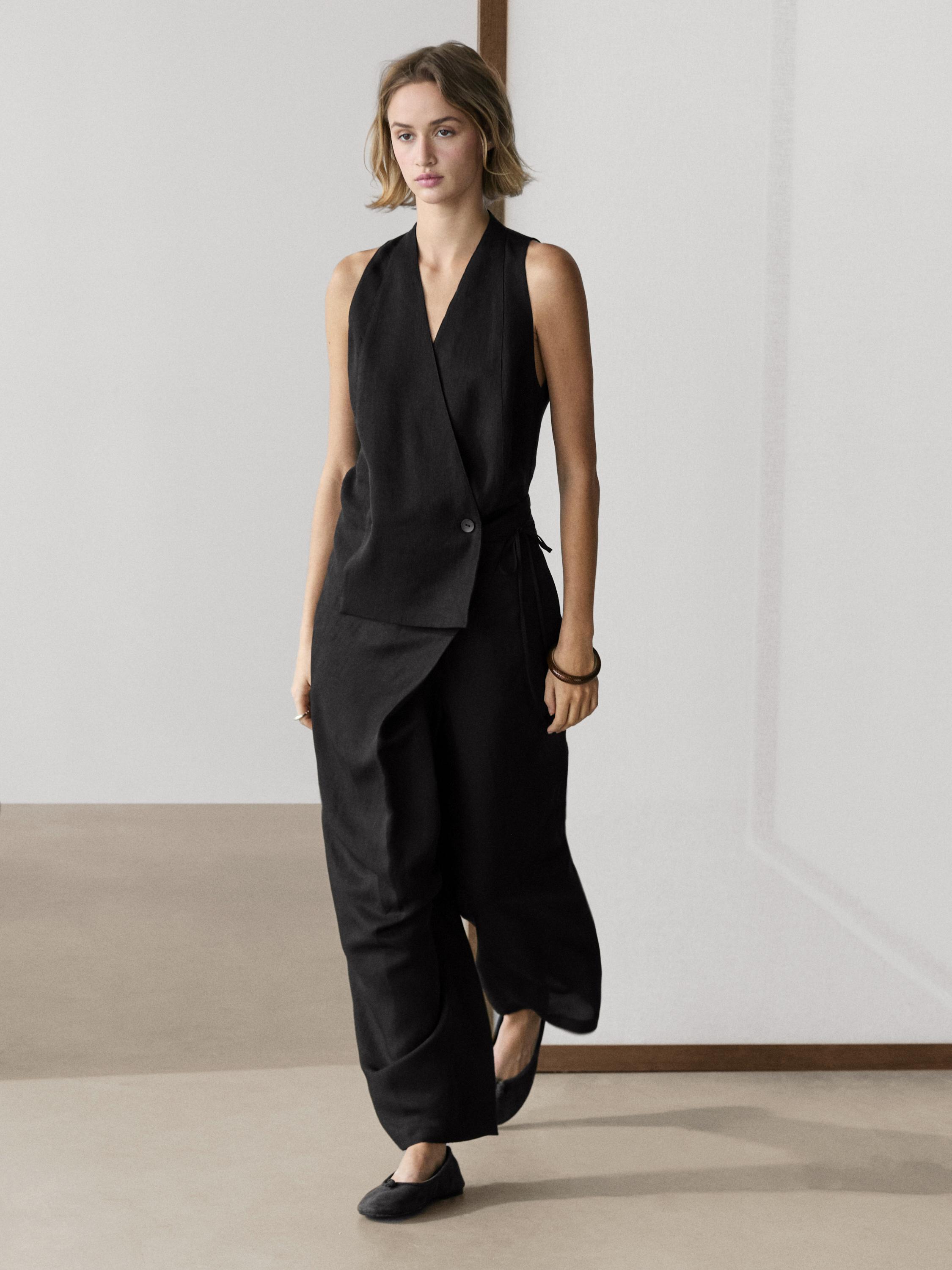 Zwarte double-breasted giletset met knoopdetails en wijde zwarte broek.