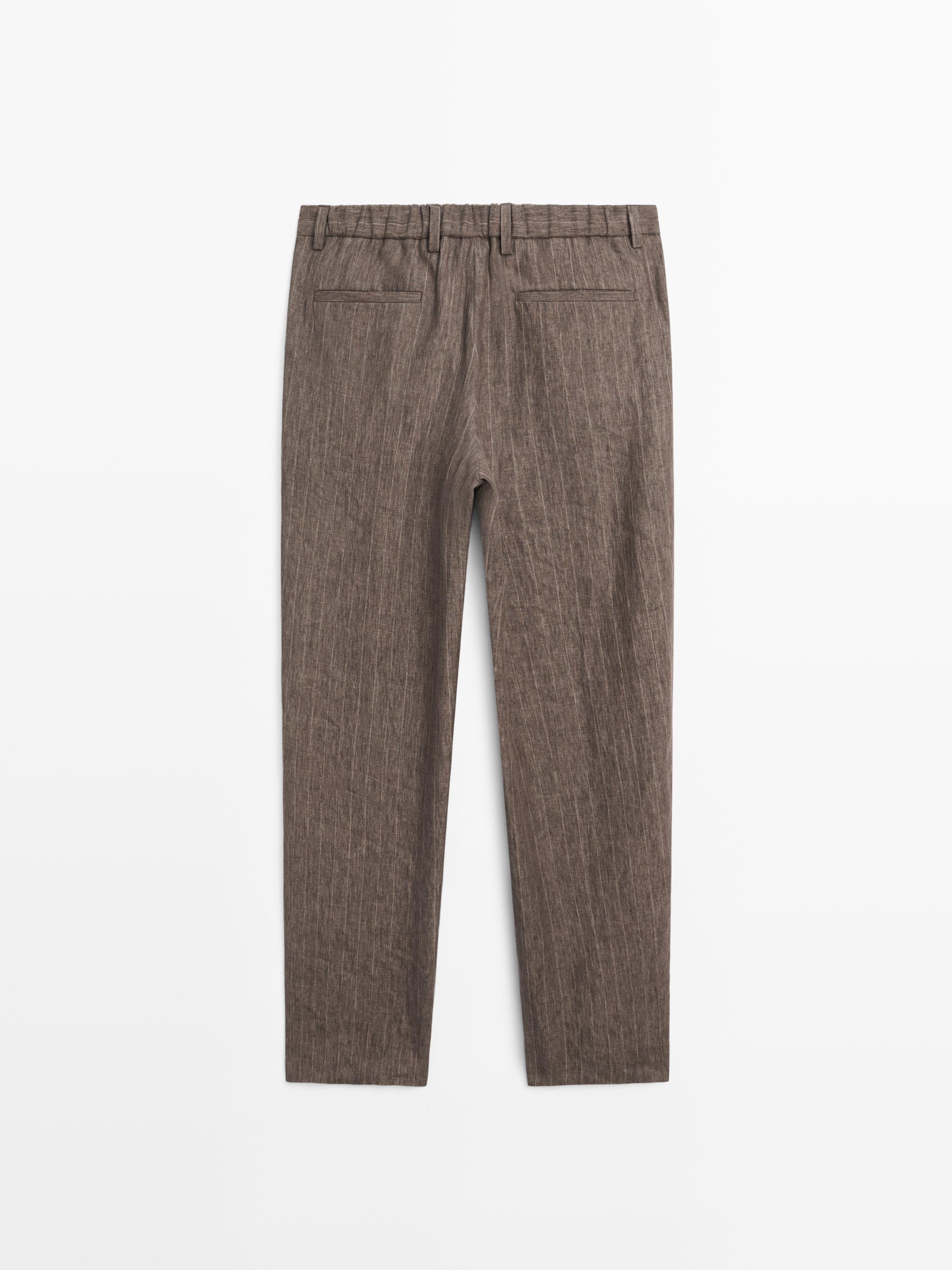 Vista posterior de pantalón marrón con rayas finas y bolsillos traseros.