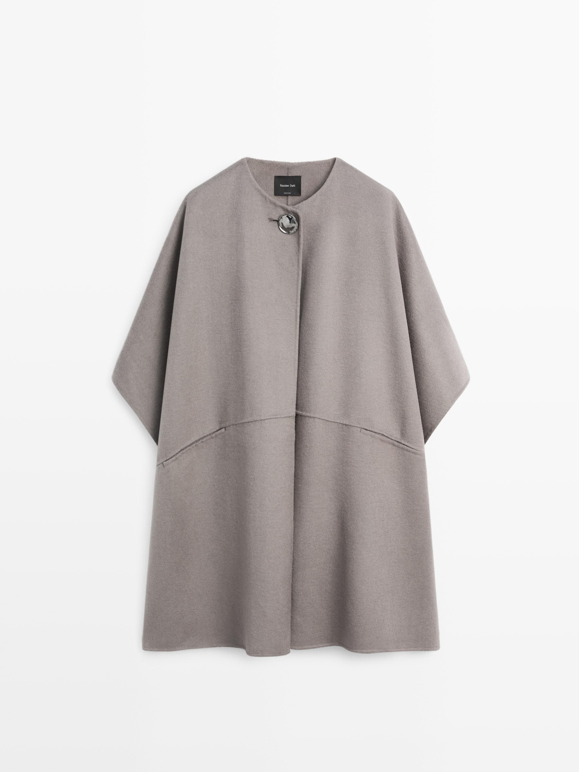 Front view of a taupe cape with button detail at the neck.
