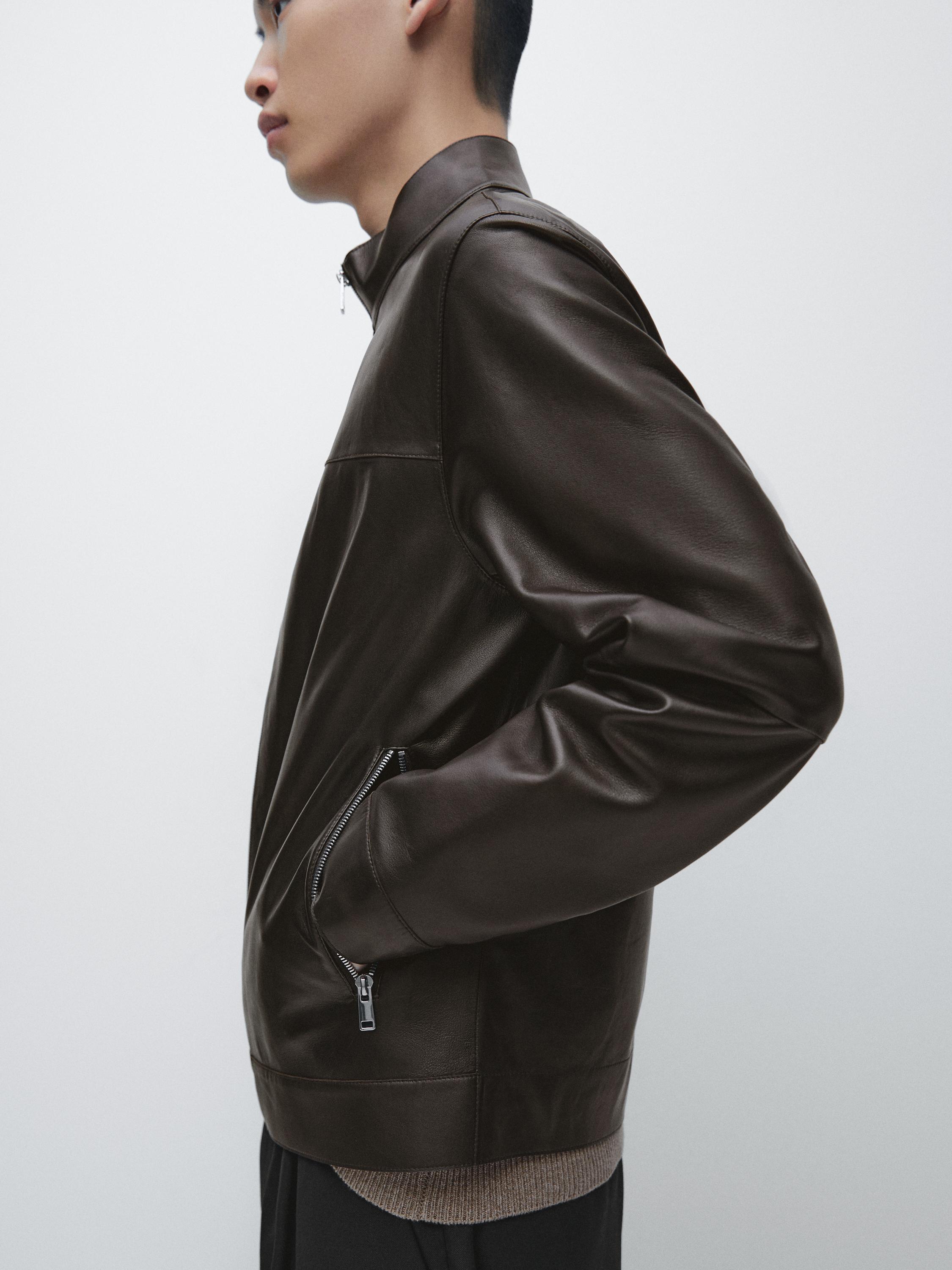 Plano médio de blusão castanho com fecho éclair e bolsos laterais, efeito gasto, vista lateral.